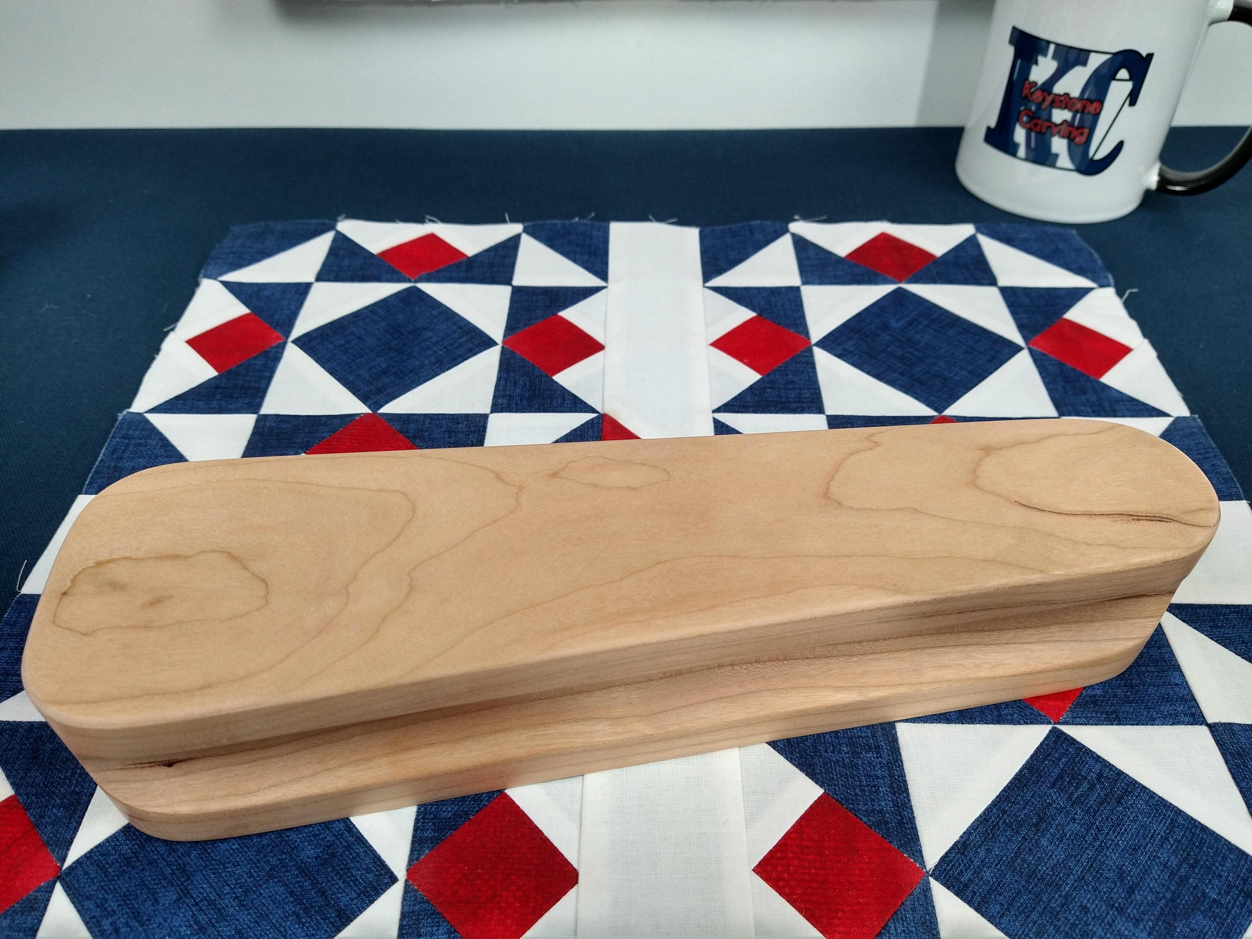 ten and a half inch tapered cherry hardwood tailors clapper setting on an Americana quilt block