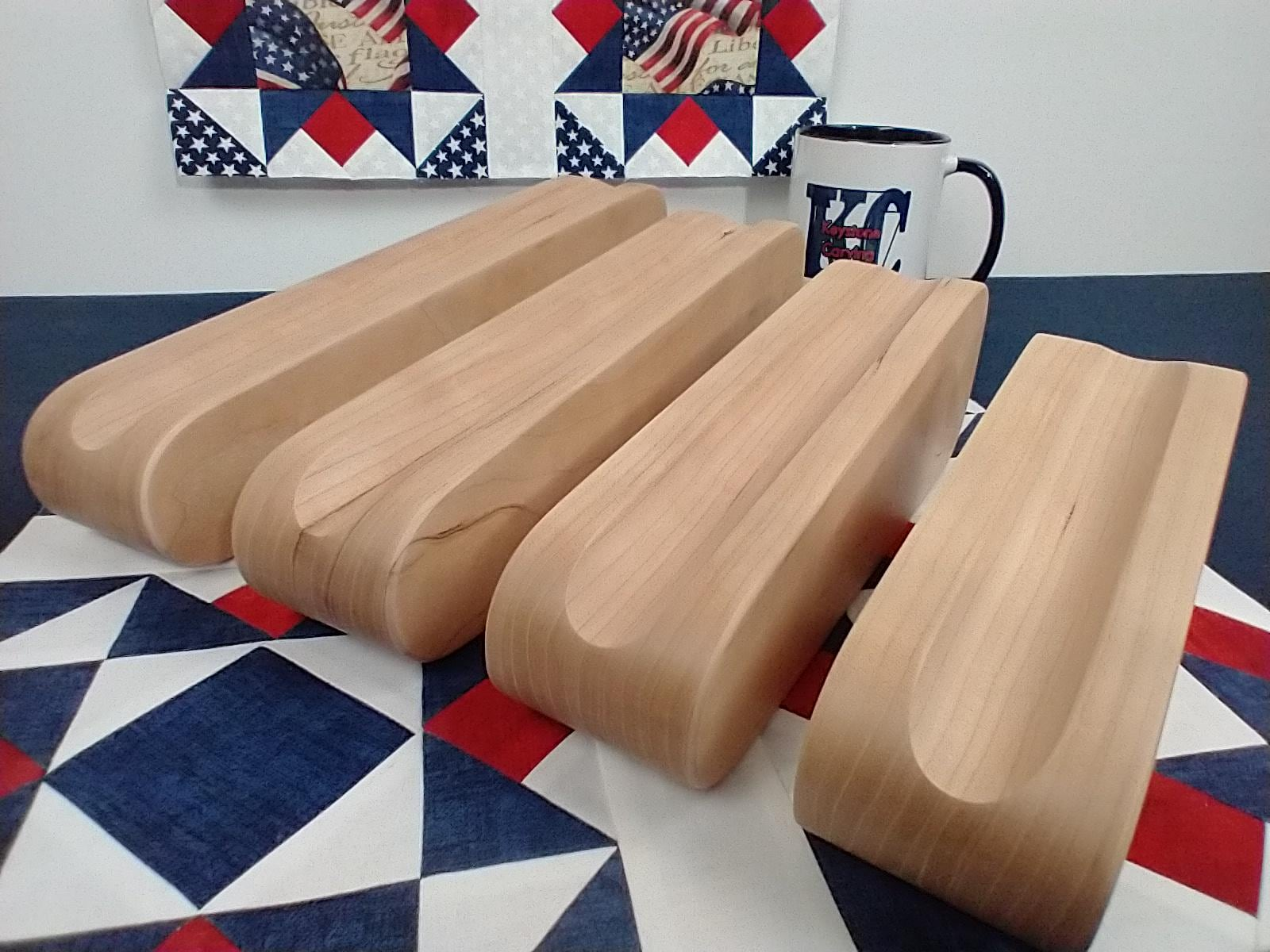 display of four different sized cherry tapered tailors clappers arranged on edge looking at the front edge on a patriotic quilt block