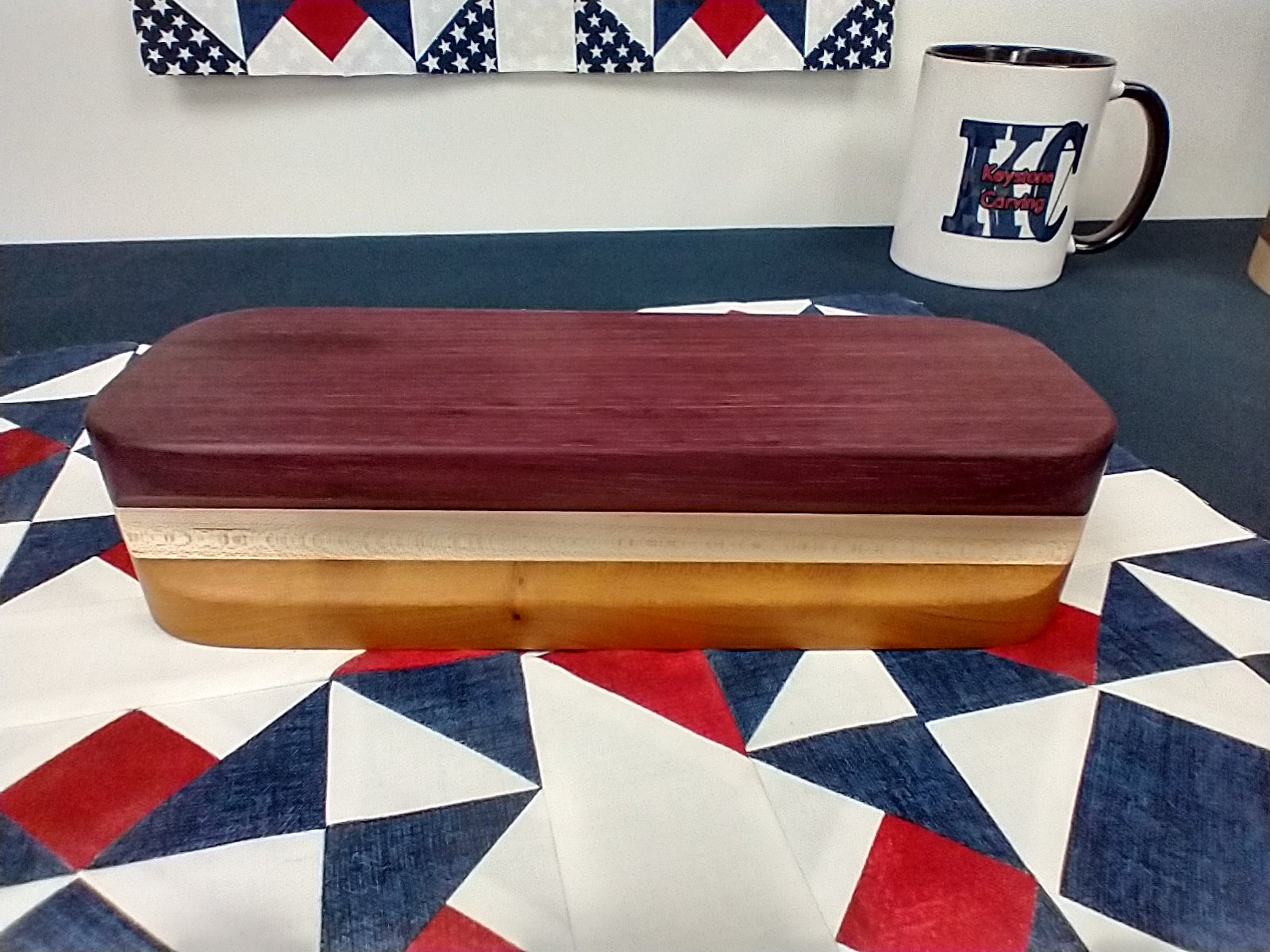 Top side view of keystone carving purple heart, maple, and cherry tailors clapper