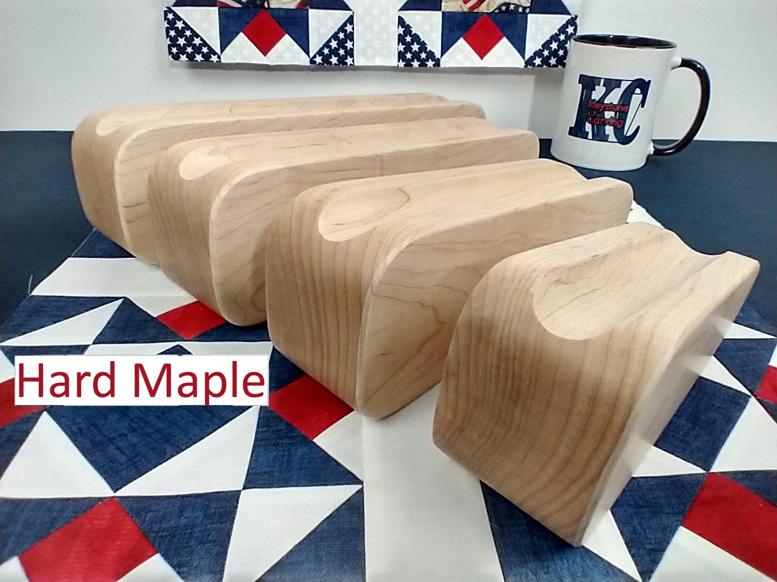 display of four different sized maple tapered tailors clappers arranged on edge looking at the back edge on a patriotic quilt block