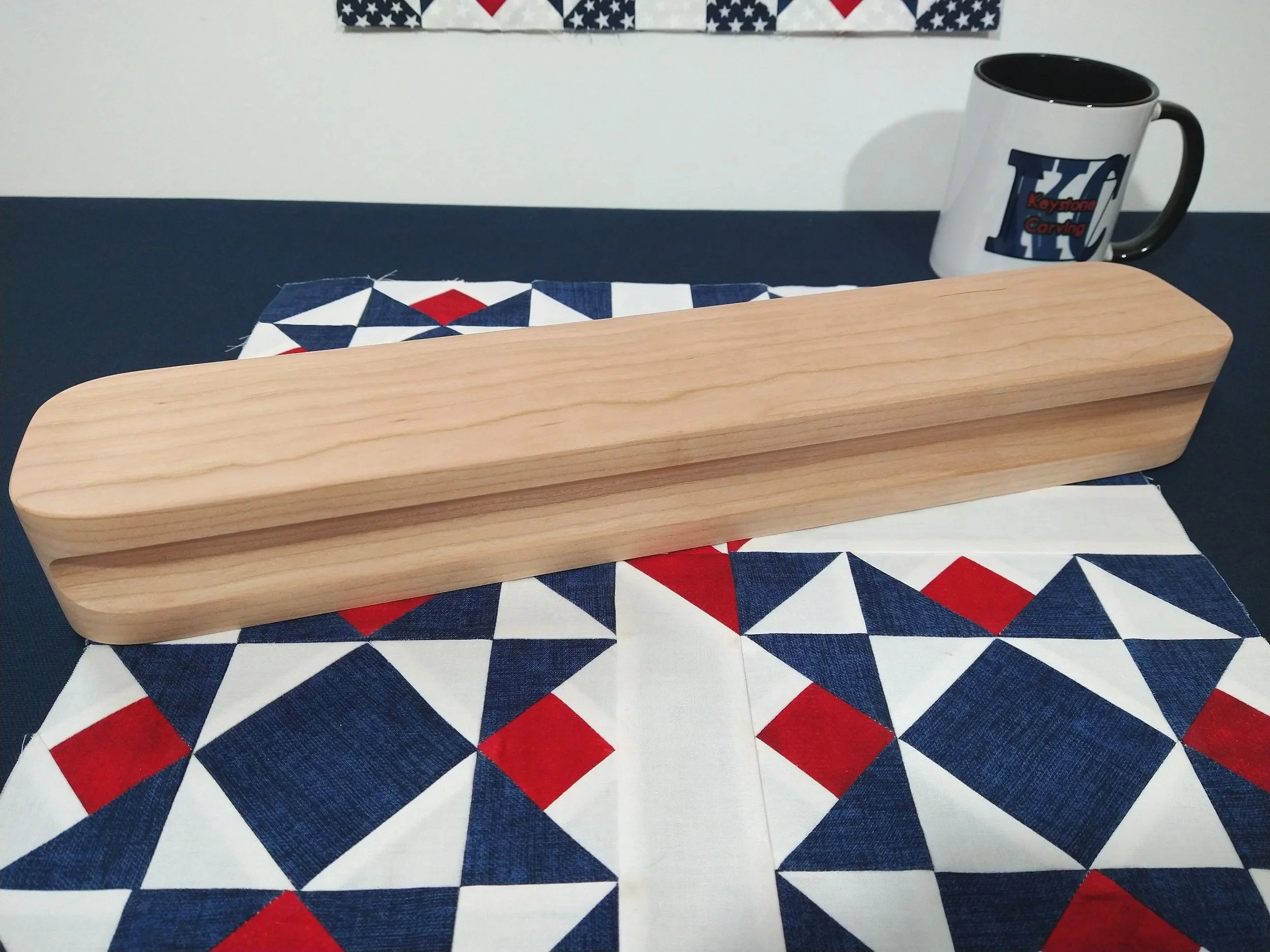 heavy cherry tailors clapper laying on a red, white, and blue quilt block