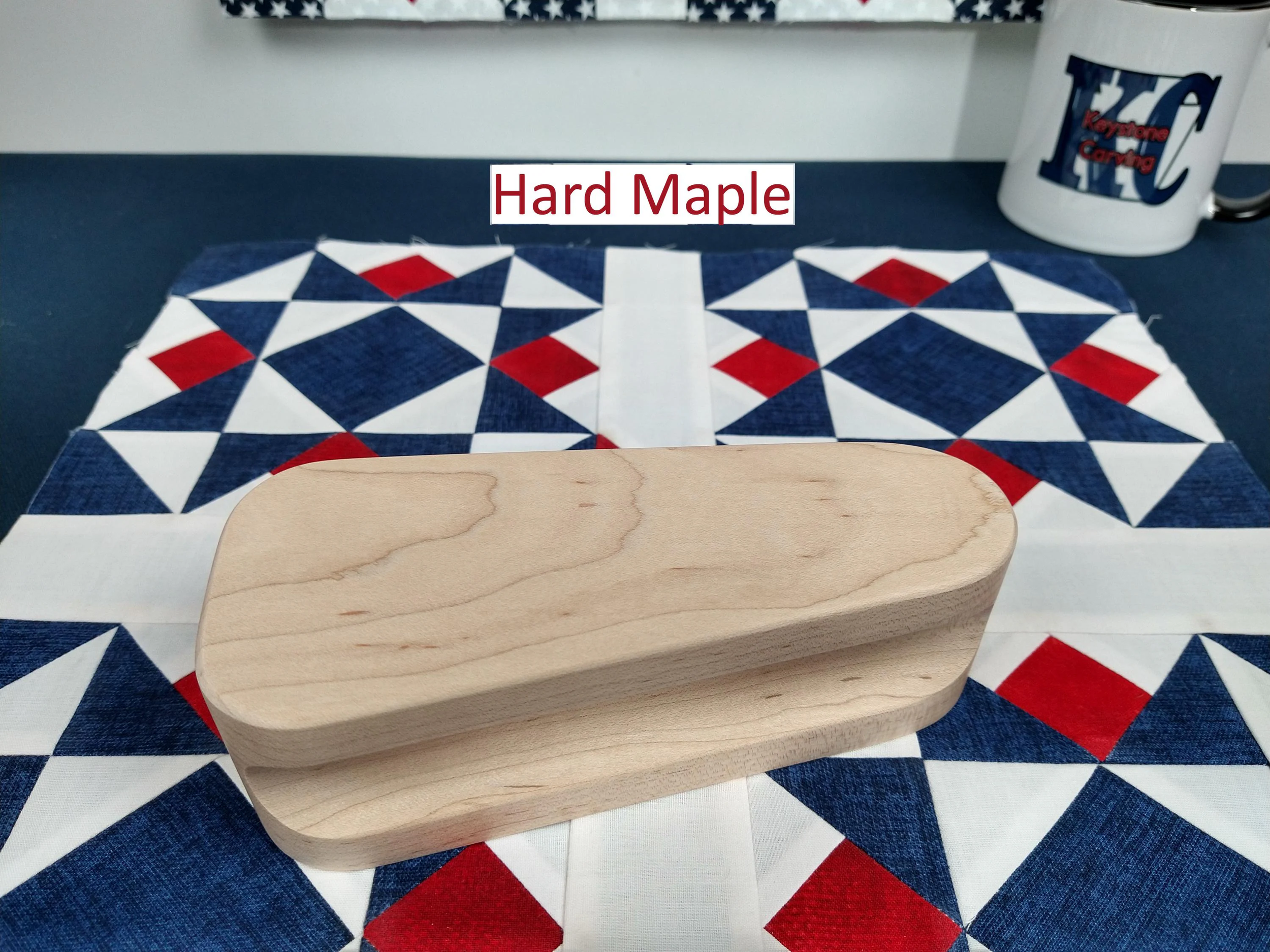 six and one half inch tapered cherry hardwood tailors clapper setting on an Americana quilt block