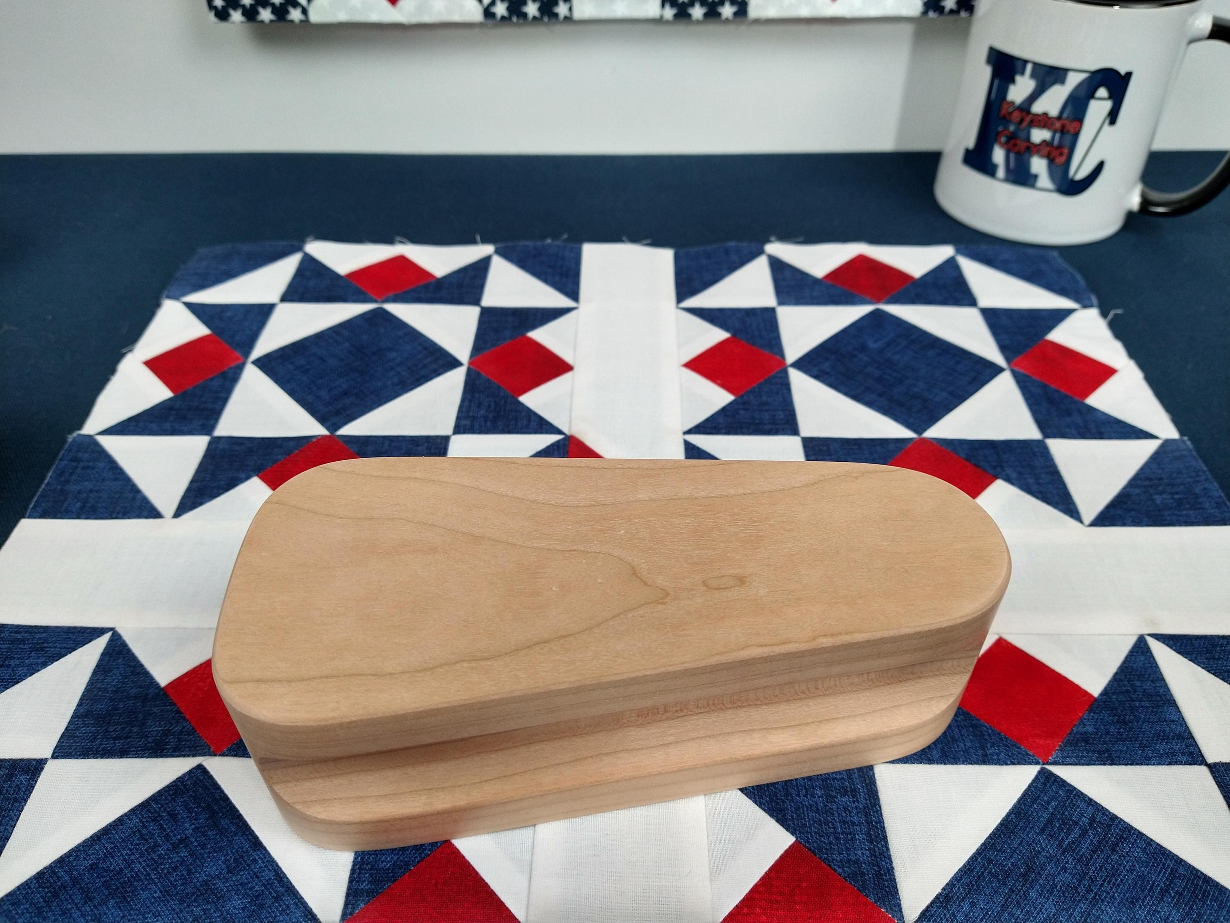 six and one half inch tapered cherry hardwood tailors clapper setting on an Americana quilt block