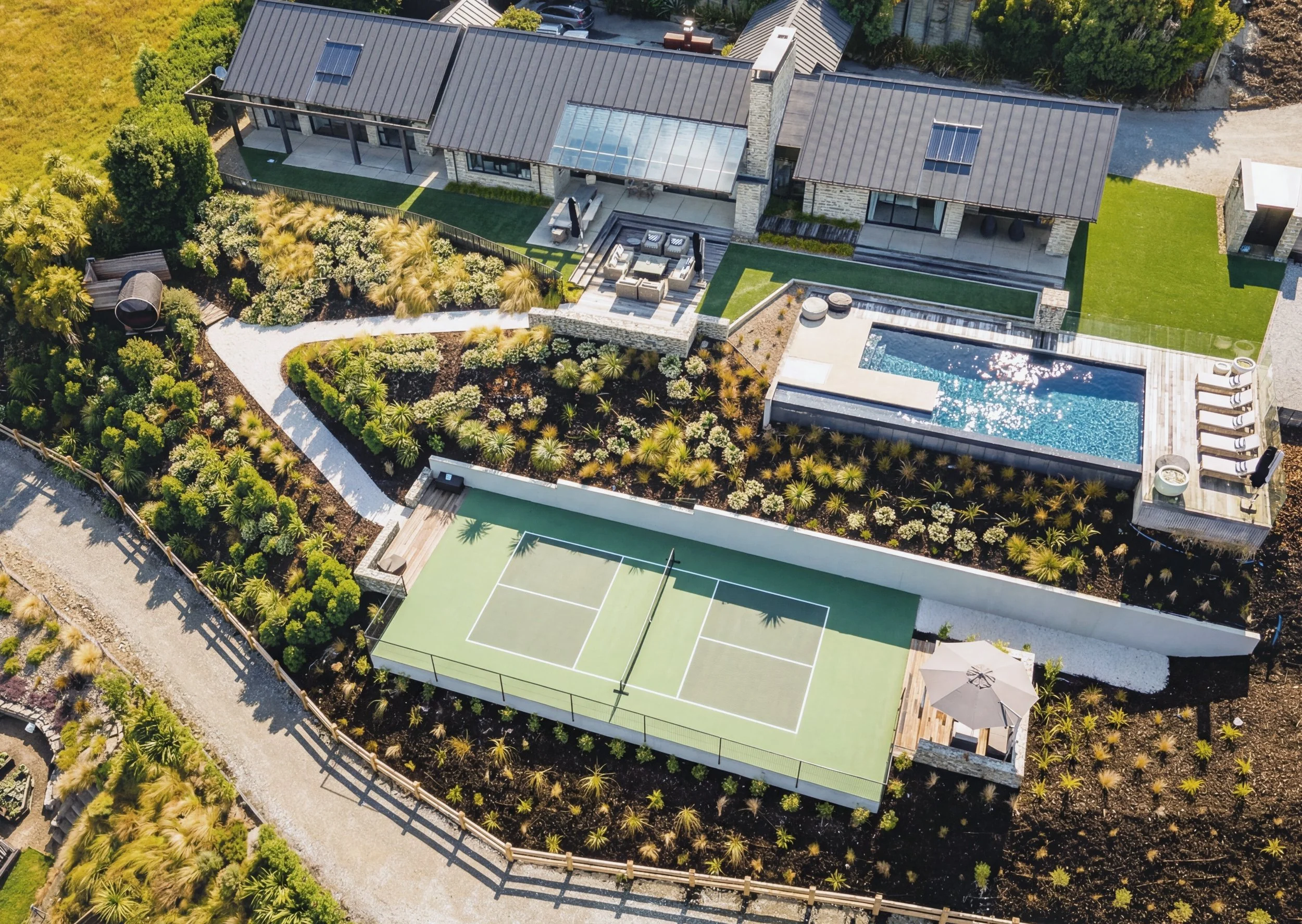 Residential landscape design featuring swimming pool, sauna, pickleball court, planitng and landscaping