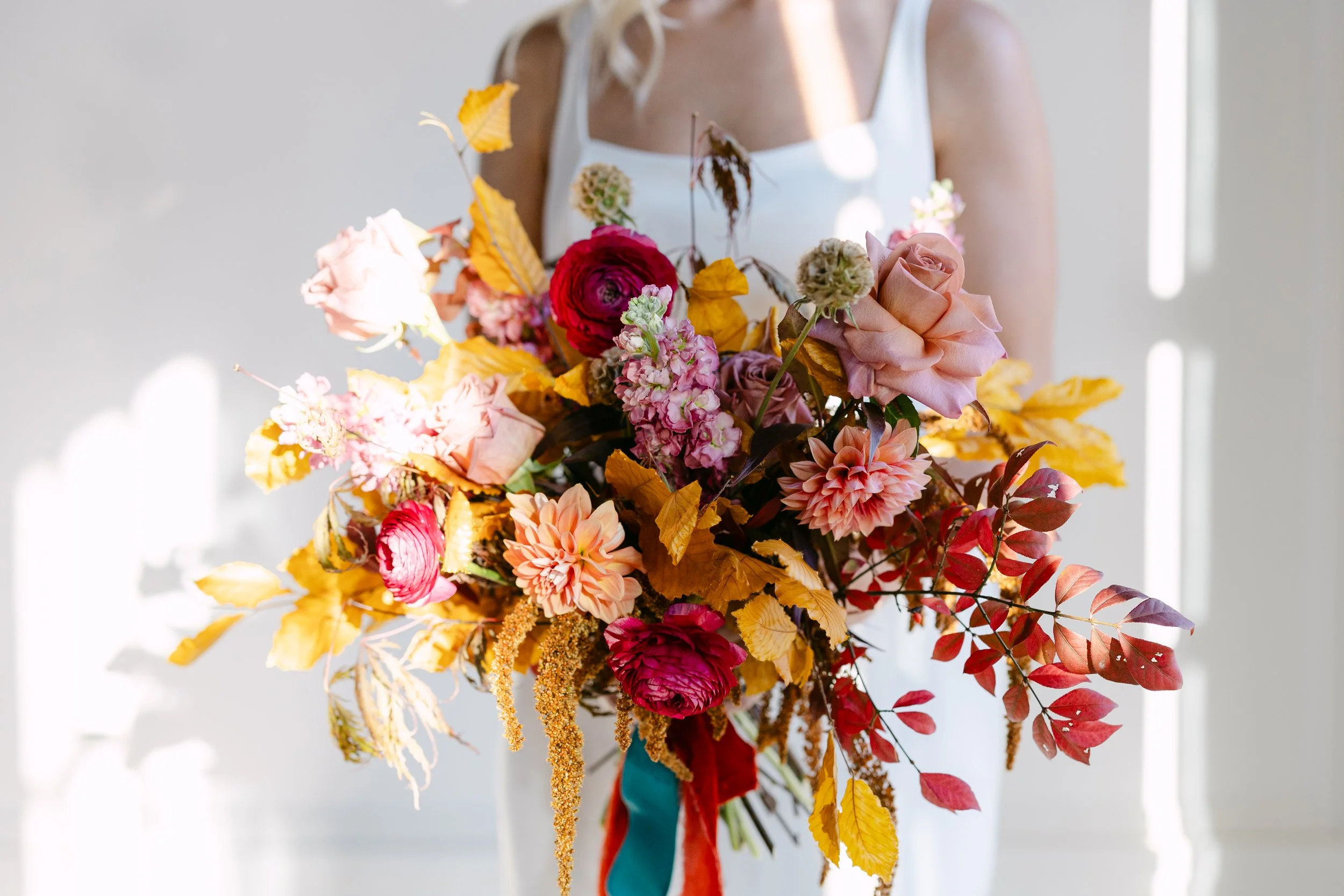 Artfully designed bridal bouquet featuring seasonal blooms in a whimsical nostalgic color palette.