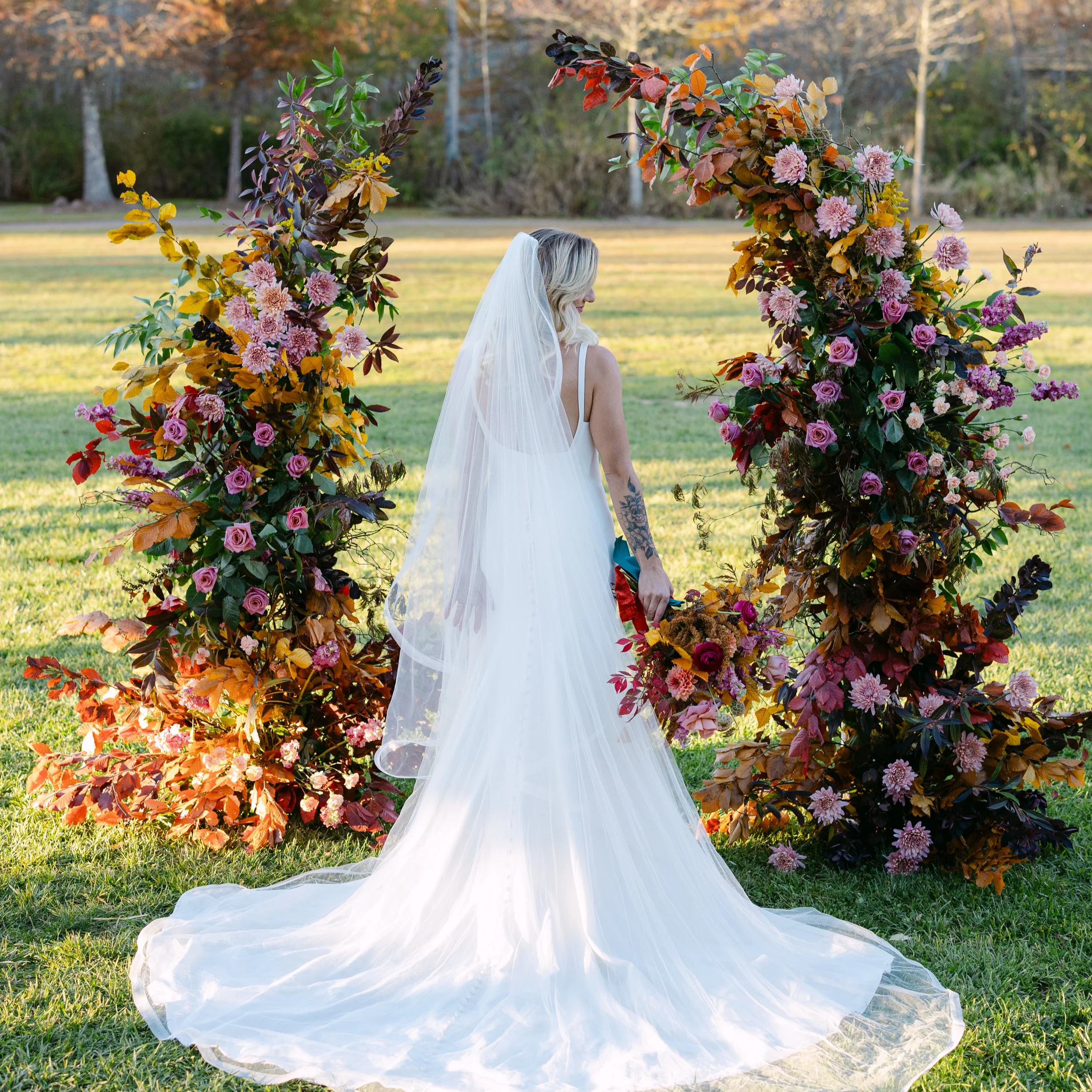 Deconstructed floral arch with bride in the fall at cashiers village green