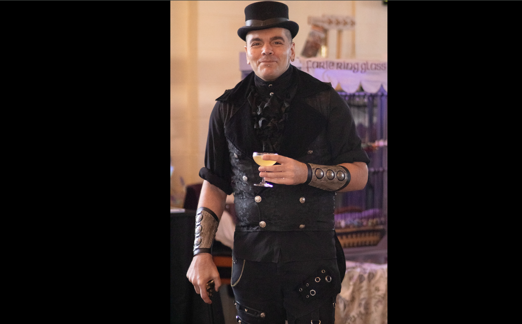 Man in steampunk attire with top hat and drink