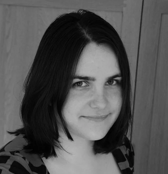Headshot of Audree Fletcher - Black and white, woman with pale skin and dark hair, enigmatic smile