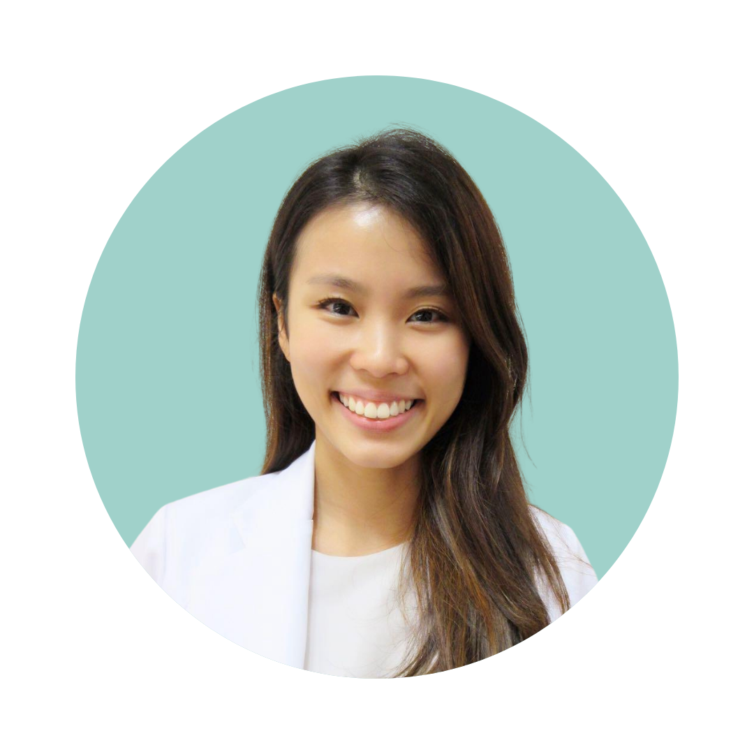 A smiling woman with long, dark hair, wearing a light-colored blazer, against a plain background.