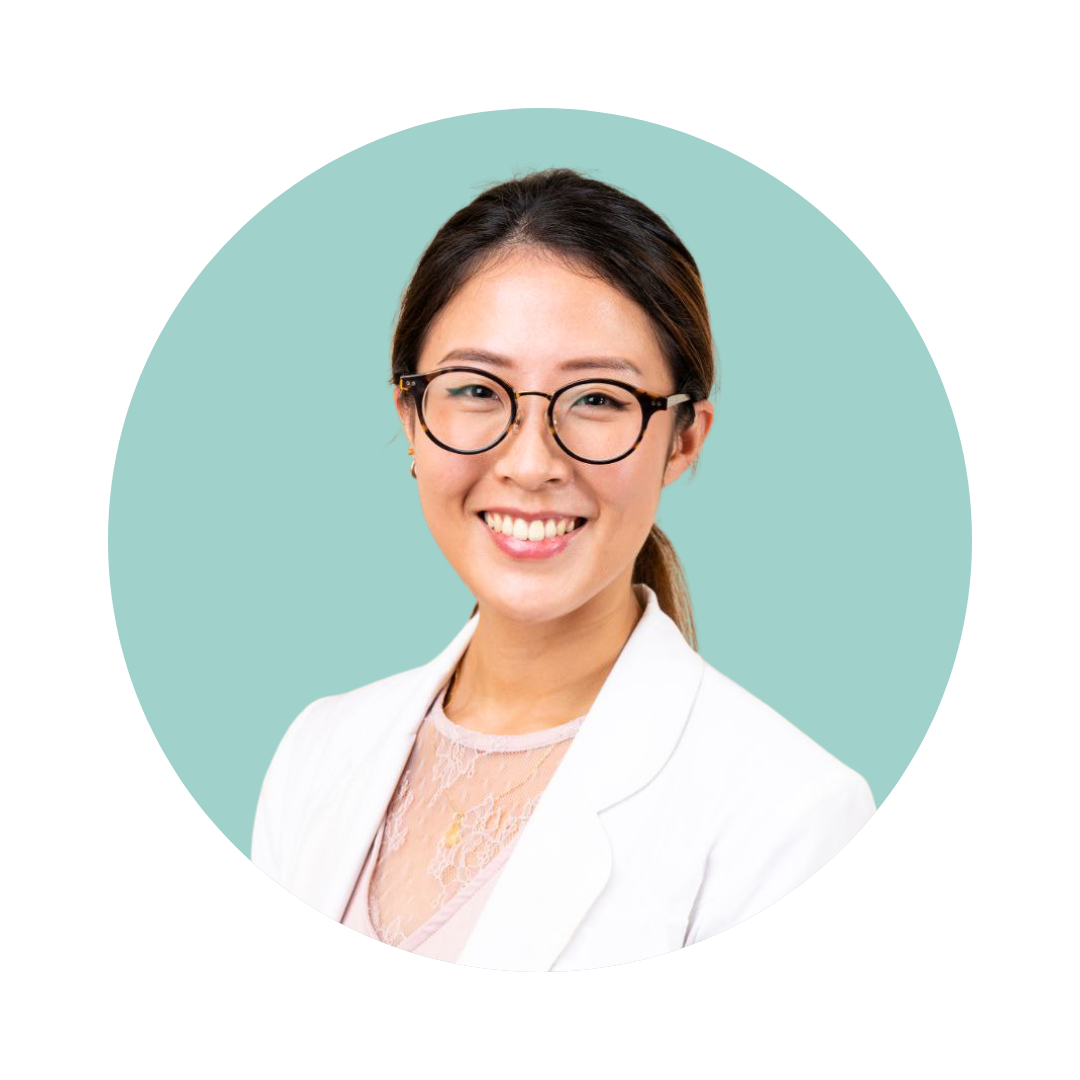 Black and white photo of a smiling woman wearing glasses and a white blazer