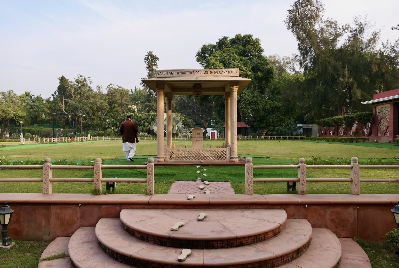 The Taj Mahal, a large white marble mausoleum with a central dome and four smaller domes, surrounded by a landscaped garden and reflecting pool.