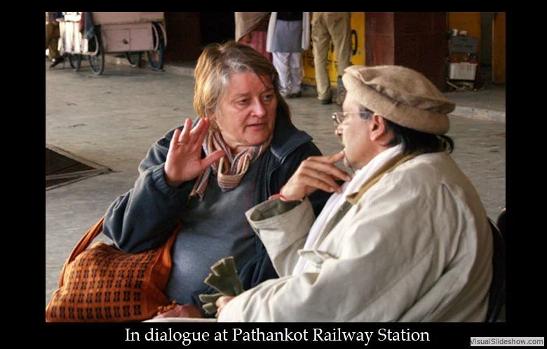 Two women having a conversation while seated at Pathankot Railway Station.