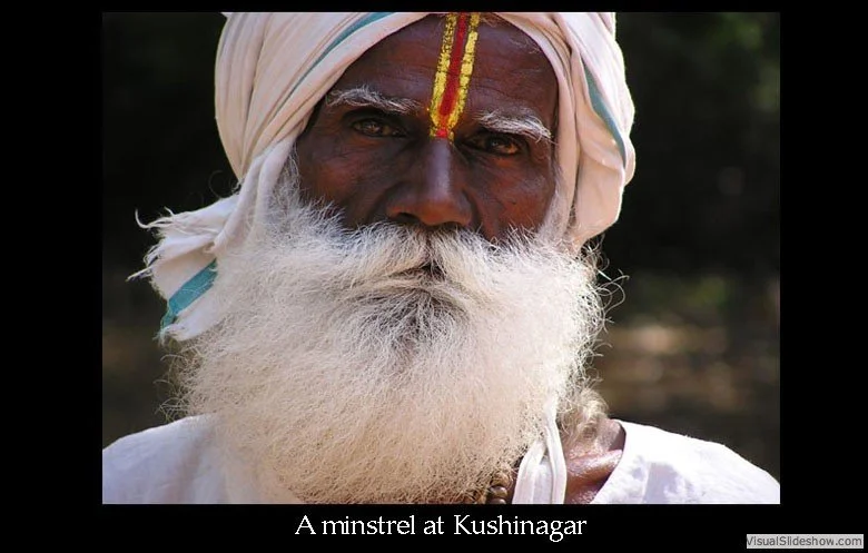 Close-up of an elderly man with dark skin, white beard, and traditional attire, including a turban and yellow markings on his forehead, in Kushinagar, India.