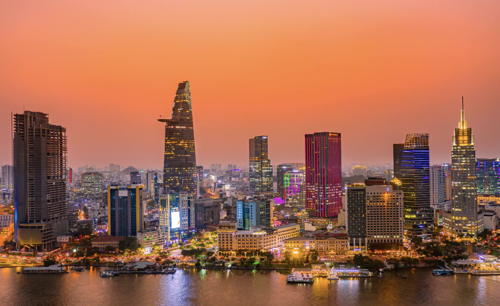 Buddha statue with a golden finish, lying on its side, covered partially with yellow cloth, with flowers nearby.