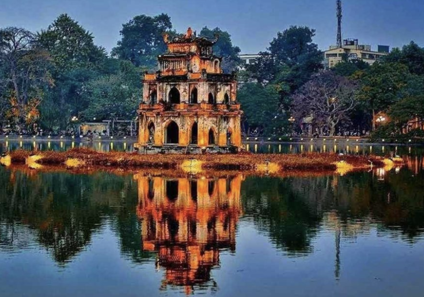 The Taj Mahal, a large white marble mausoleum with a central dome and four smaller domes, surrounded by a landscaped garden and reflecting pool.