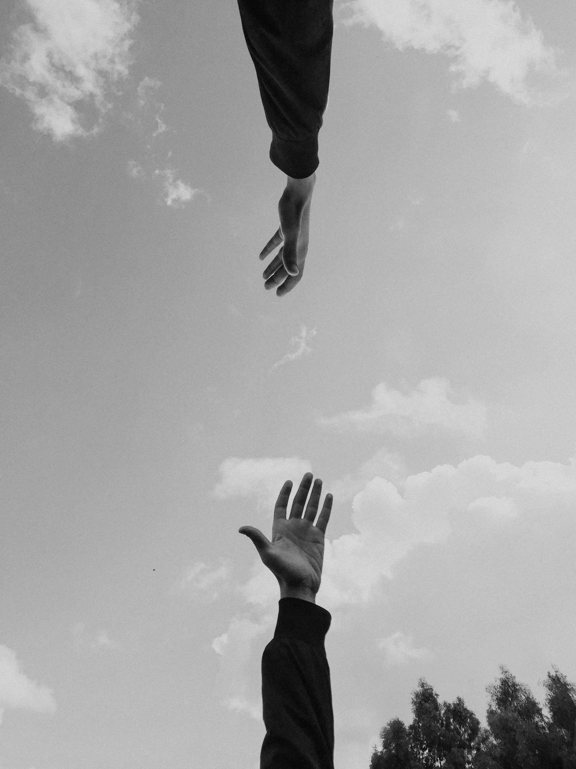 Person holding a lightbulb with string lights inside, glowing warmly in a dark setting.