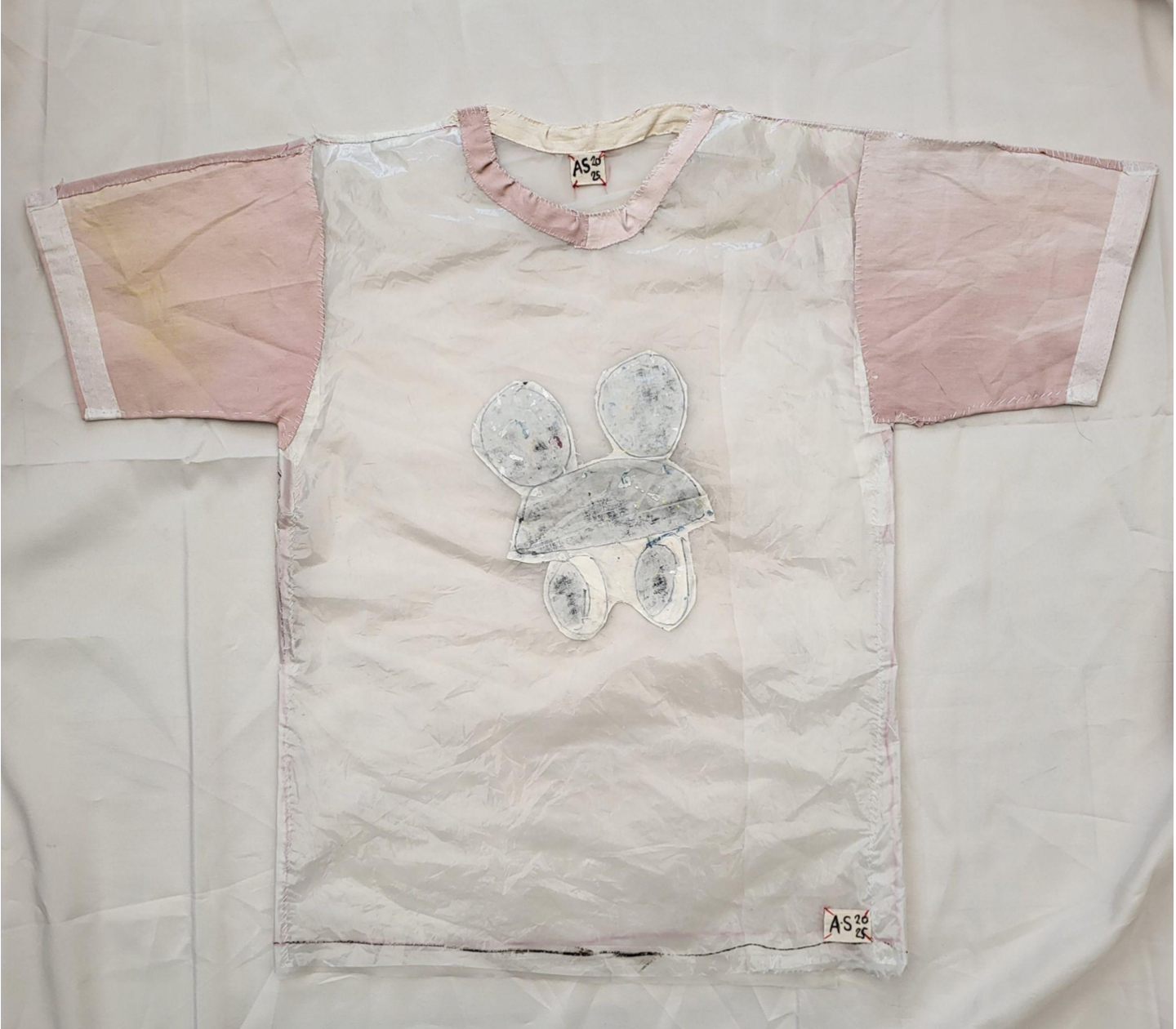  Ant Stevens 
 FAST FASHION FOR PEOPLE LIVING AT THE END OF THE WORLD (1)
 Large unisex Tshirt
 2025
 Hand stitching, recycled shower curtain, cotton fabric,plastic packaging, calico, acrylic