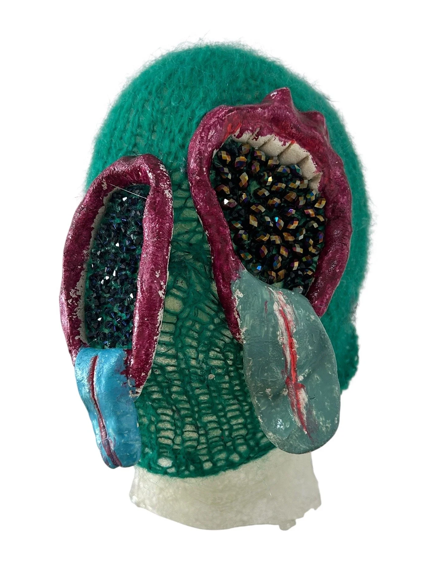  UNTILTED  
 Knitted mask
  27 X 17 X 23 cm 
 Alpaca thread, varnished salt dough,
Svarowski crystals
 2025