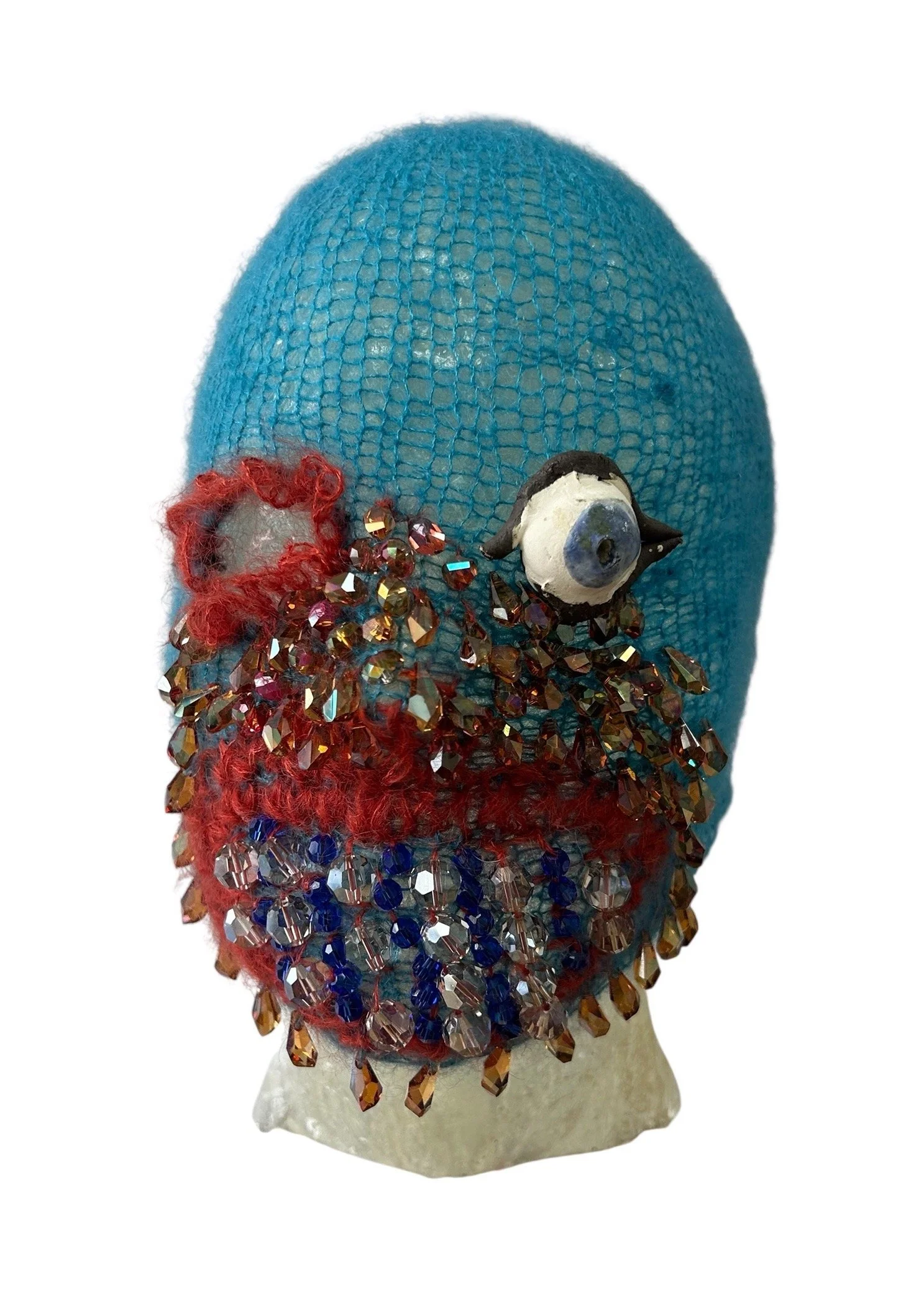  UNTILTED  
 Knitted mask
  27 X 17 X 23 cm 
 Mohair thread, glazed ceramic, Svarowski
crystals
 2025