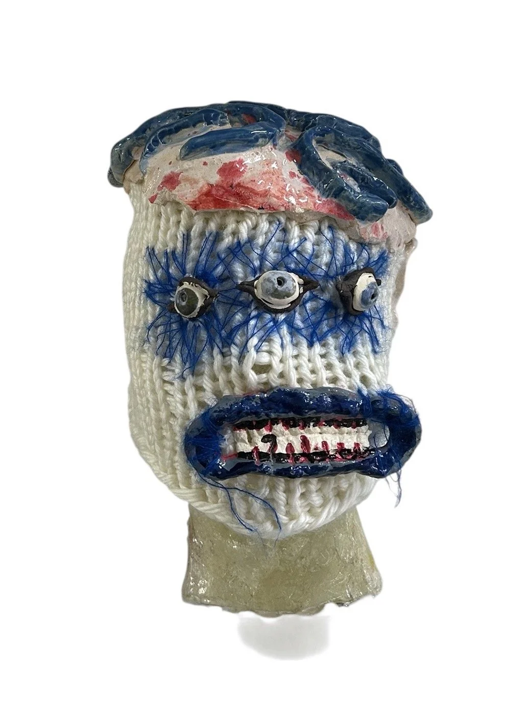  UNTILTED  
 Knitted mask
  27 X 17 X 23 cm 
 Wool, polyester, glazed ceramic, varnished salt dough
 2025