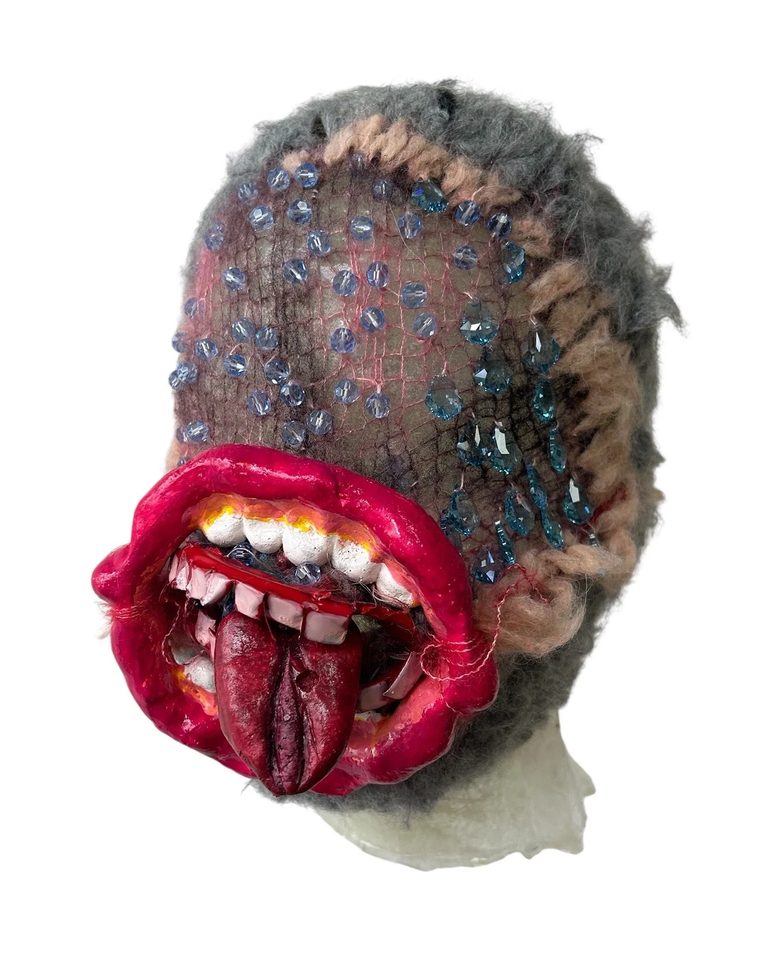  UNTILTED 
 Knitted mask
  27 X 17 X 23 cm 
 Alpaca and mohair thread, varnished salt
dough, Svarowski crystals, tin
 2025