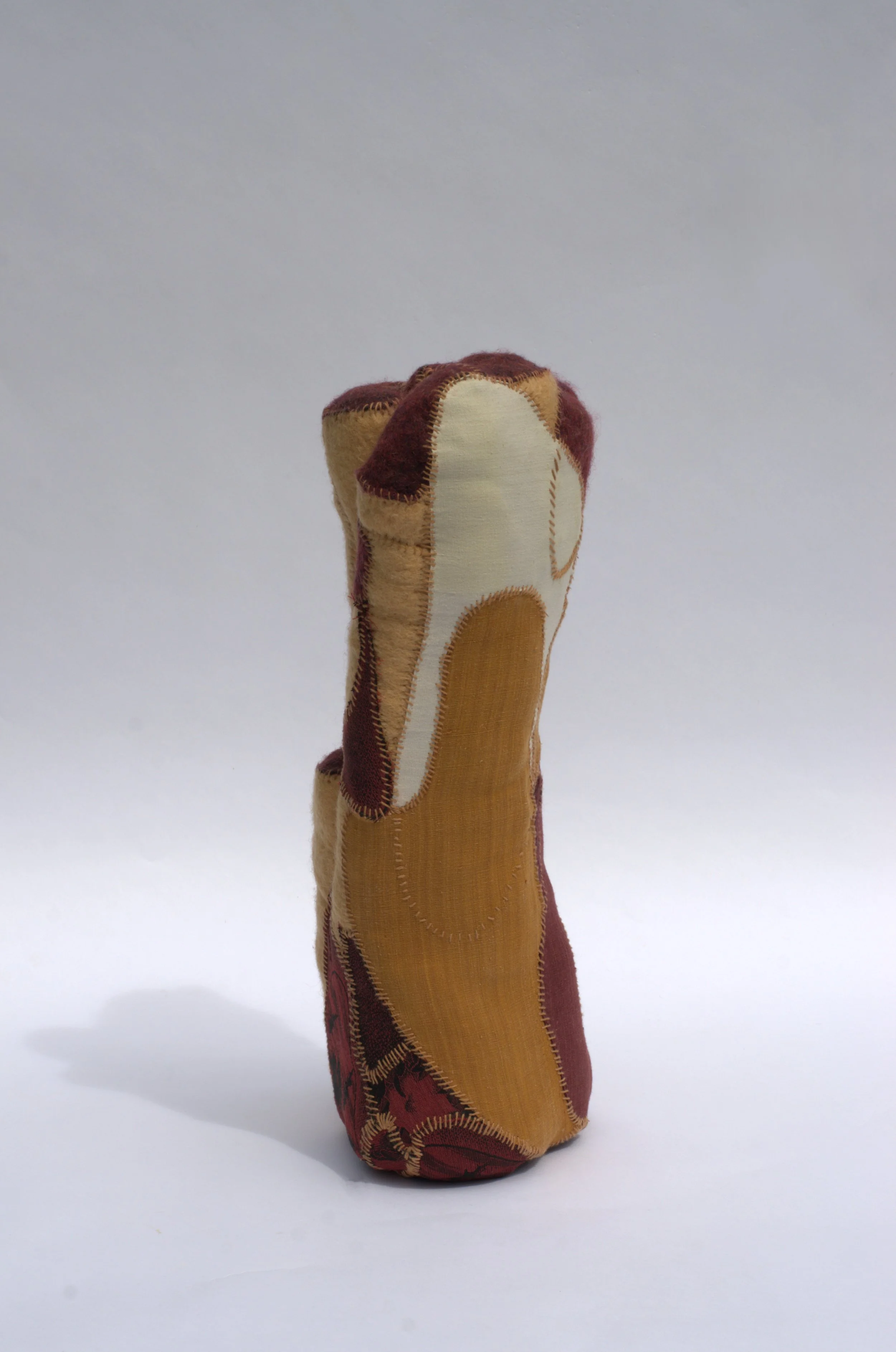  Kristina de Coninck 
 The essence of ochre
 Wool blankets, vintage japanese
kimono and mexican dress pieces,
cotton threads
 55 × 25 × 20 cm
 2023