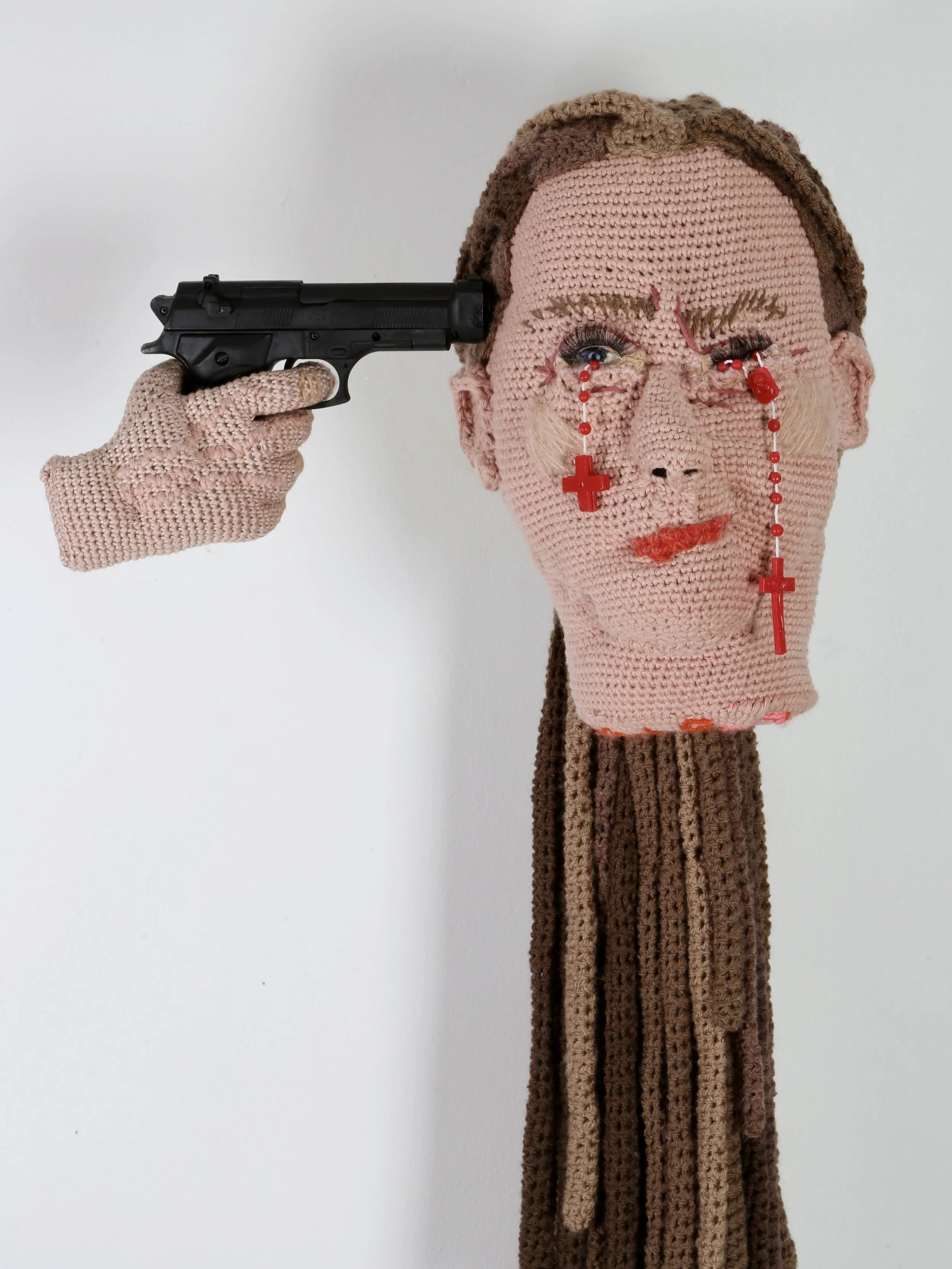  Tatum Kempers 
 HOLY SHIT STORM
 Yarn (cotton, wool, acrylic, recycled plastic bottle yarn), teddy bear stuffing, rosaries, children’s toy, fake eyelashes
 approx. 80 × 55 cm
