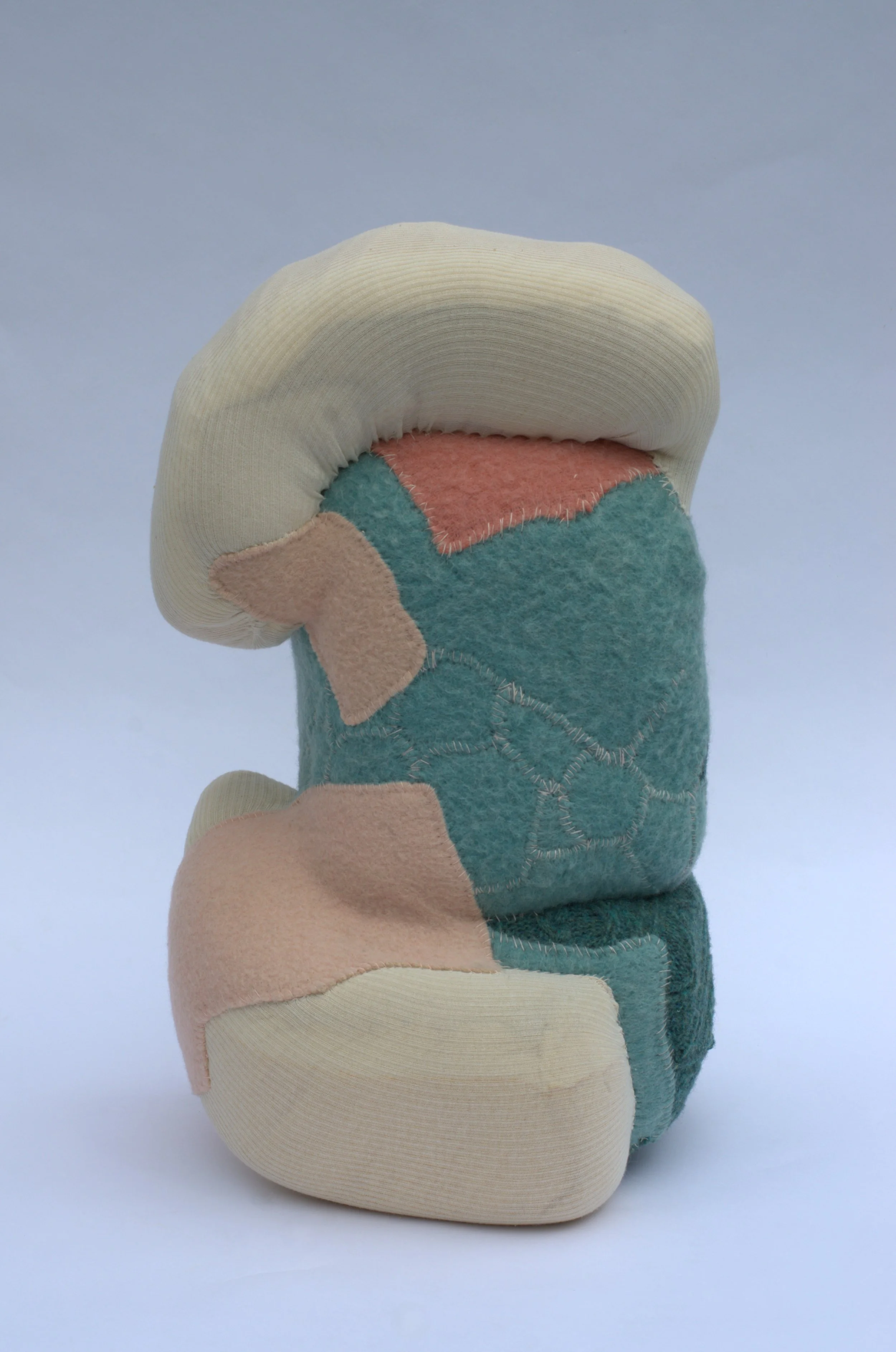  Kristina de Coninck 
 Nexus
 Sections of mattress, wool patches,
tubular medical mesh, sweater
fragments and cotton threads
 62 × 35 × 38 cm
 2024
