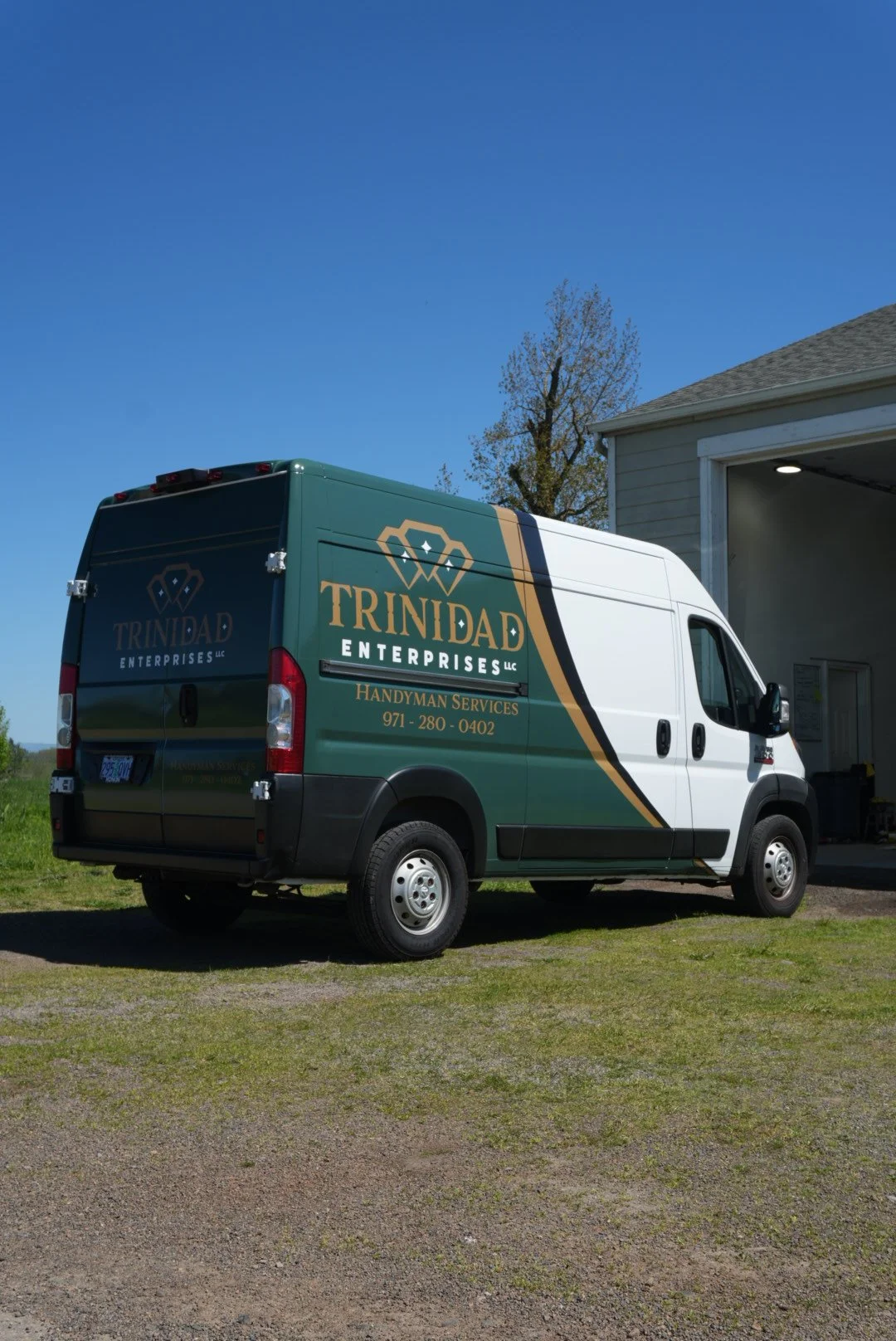 rear shot of whiter van with parial wrap showing a nice forest green color with black and gold accents that show the logo large and get the message across to clients and clearly show what services this wrap customer offers and help get them leads 
