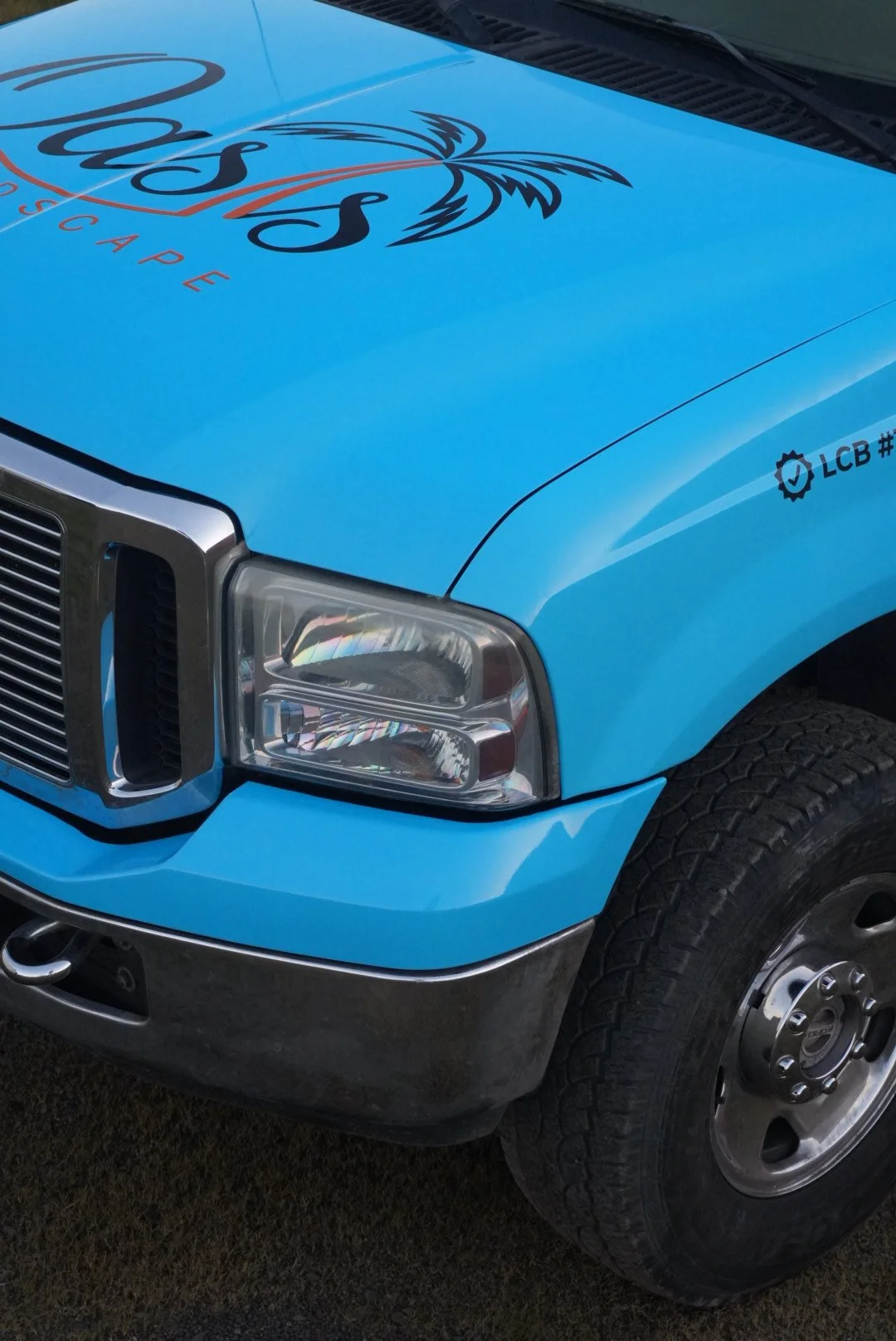 Close-up of the front of a blue vehicle with a logo on the hood and the word 'Oceans' visible.