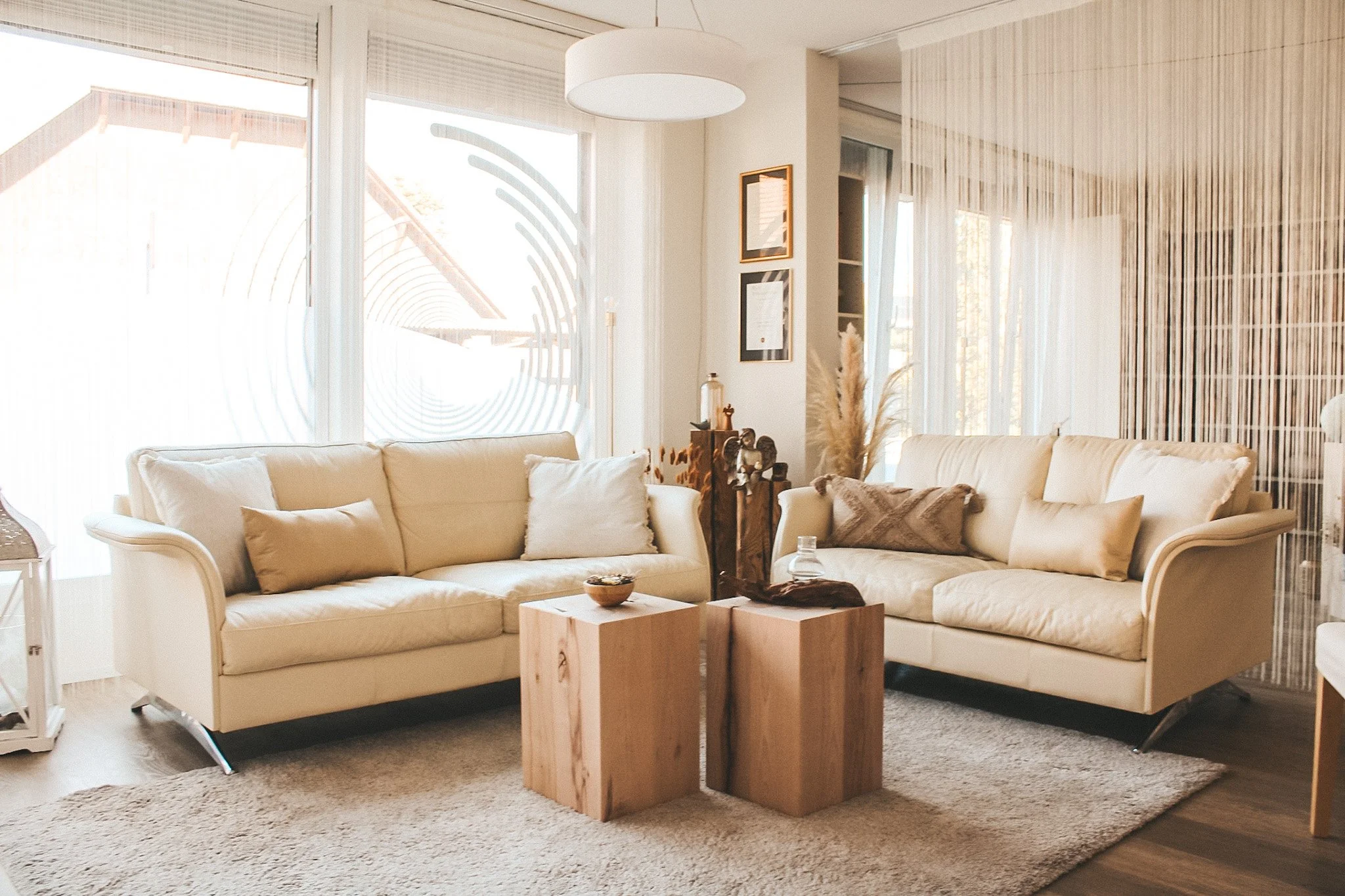 Moderner und heller Beratungsbereich mit bequemen Sofas und natürlichen Holzelementen. Die beruhigende Einrichtung lädt zu einfühlsamen Gesprächen in diskreter Atmosphäre ein.