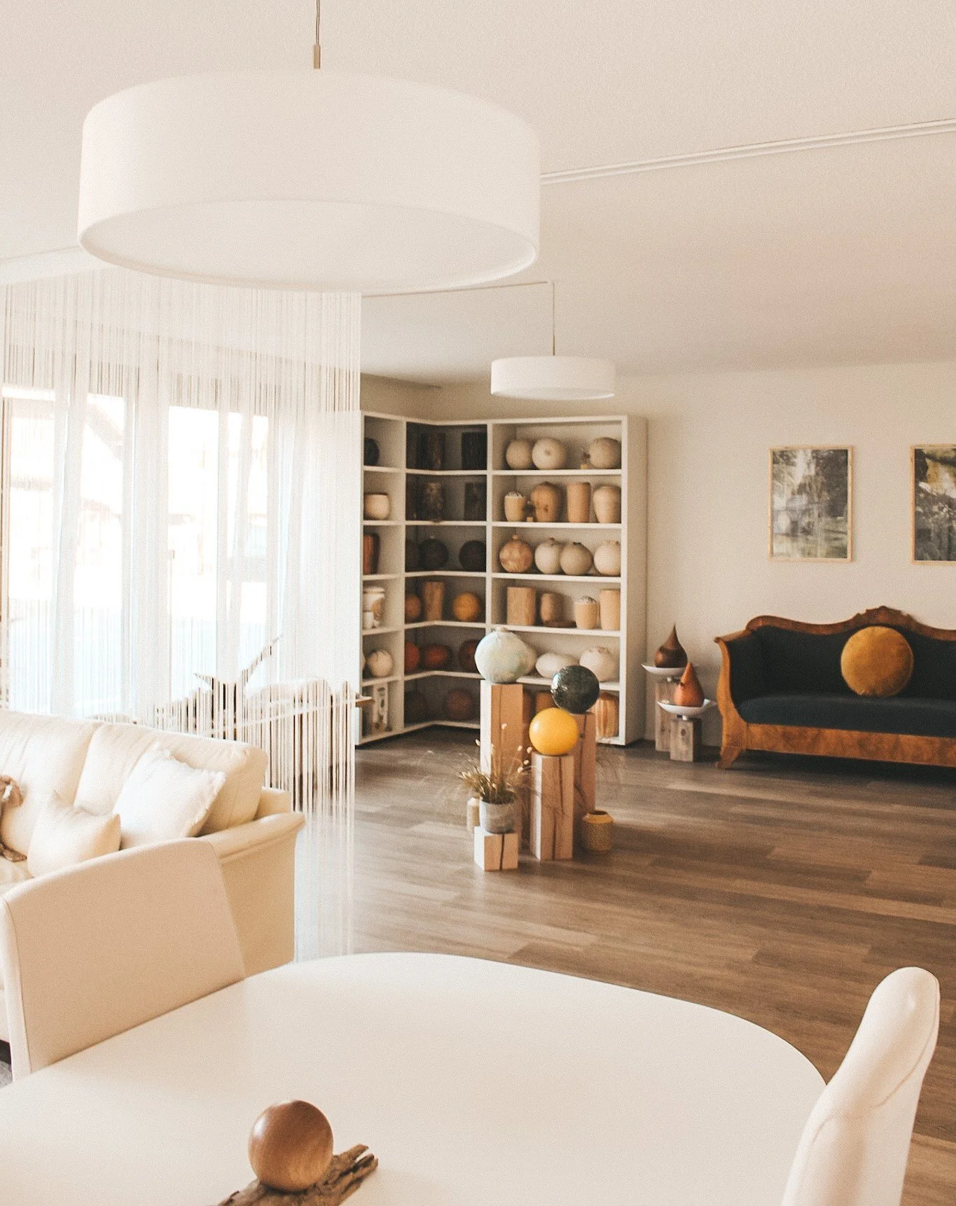 Offener und lichtdurchfluteter Beratungsraum mit Blick auf die Urnenausstellung, gemütlicher Sitzgelegenheit und stilvoller Einrichtung. Die ruhige, klare Raumgestaltung schafft eine würdevolle Atmosphäre für einfühlsame Gespräche rund um Abschied un