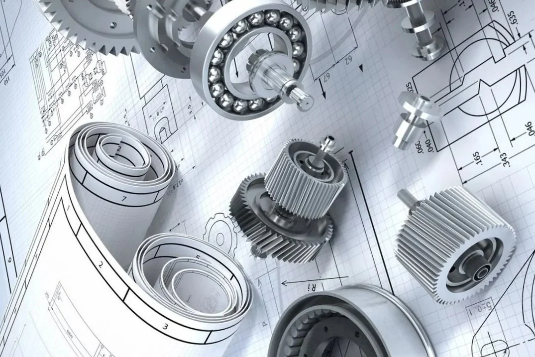 Several metal gears and mechanical parts placed over technical engineering blueprints.