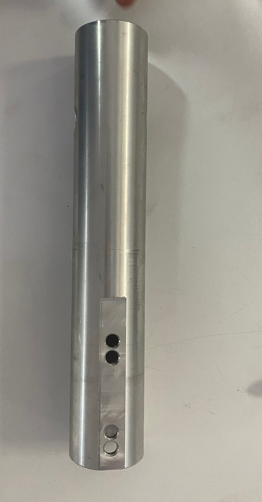 A cylindrical metal object with a rectangular panel containing three circular openings on its side.