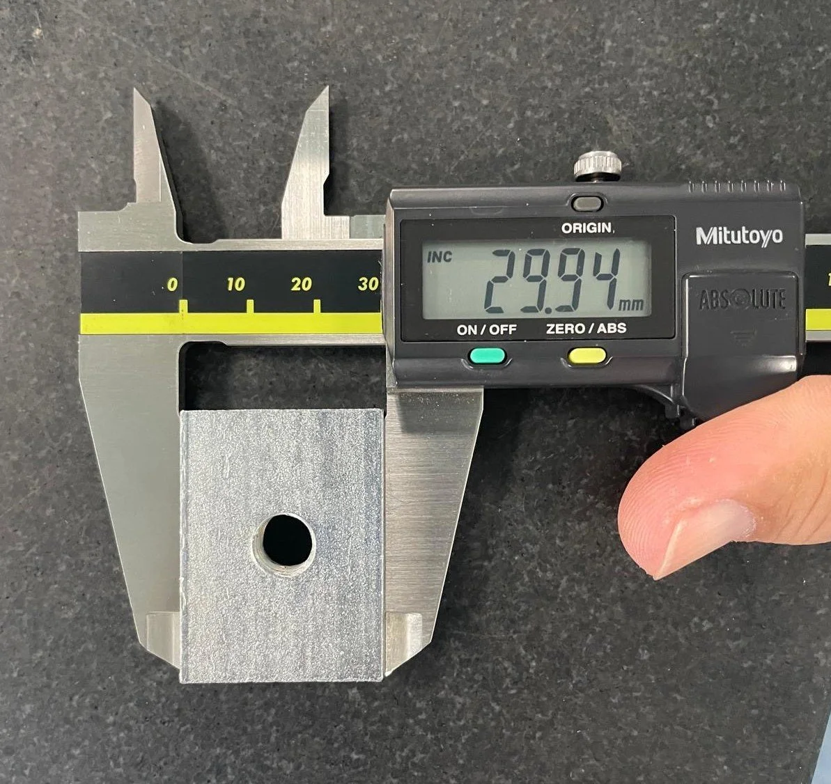 A digital caliper measuring a metallic object, showing a reading of 29.94 millimeters.