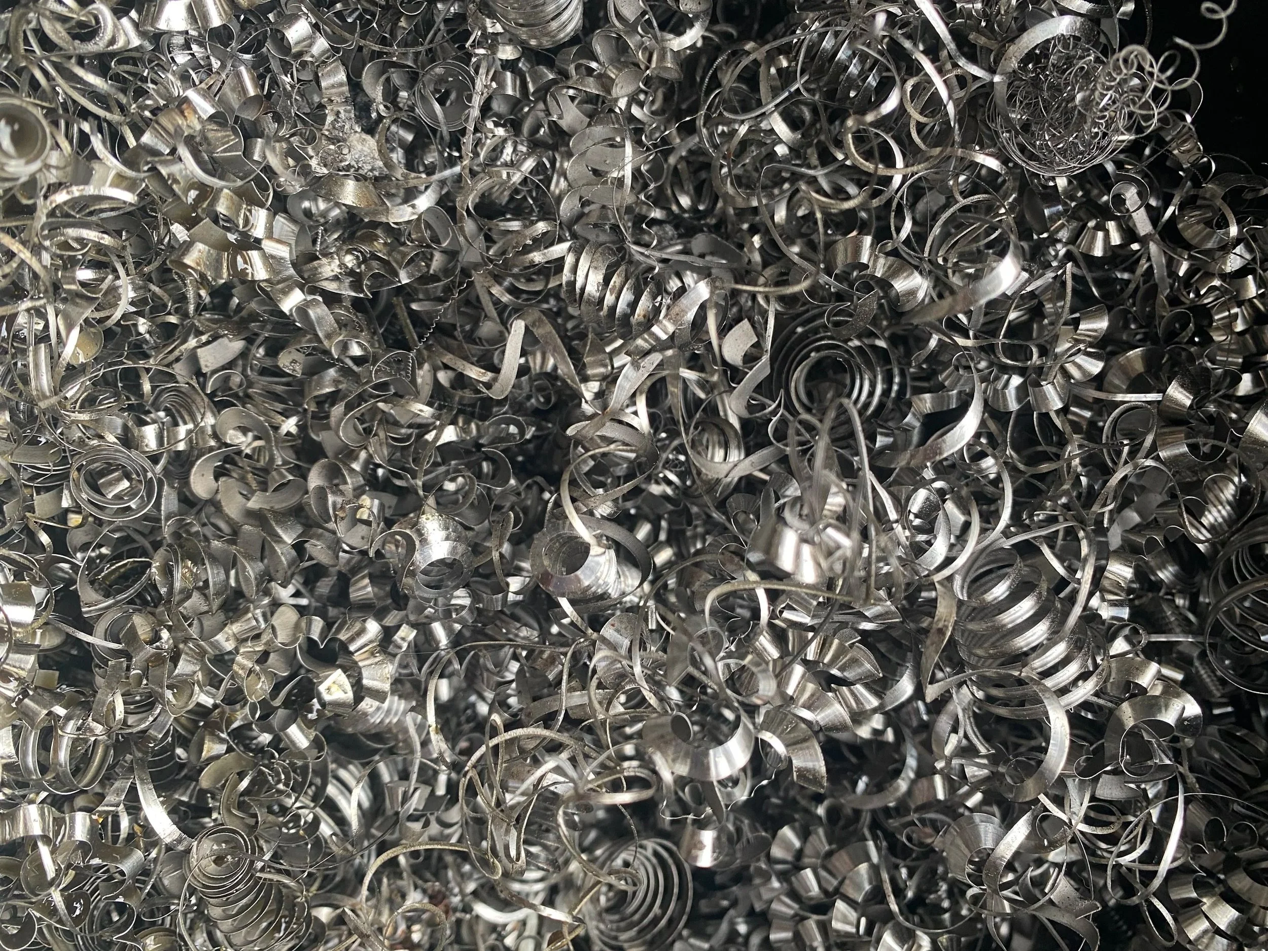 A close-up of a large pile of shiny, metallic metal shavings and curls.