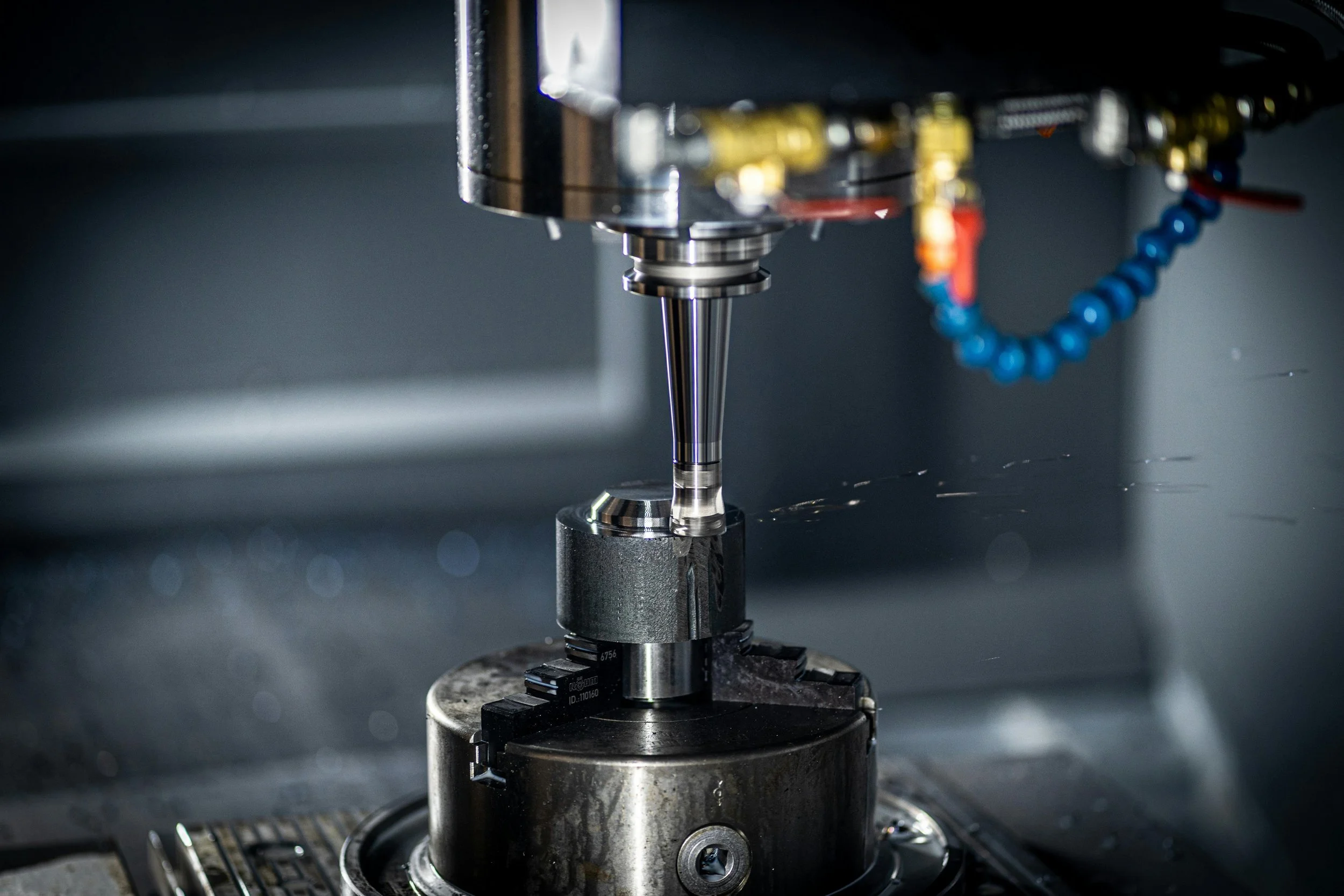 Close-up of a CNC machine cutting or machining a metal part in a manufacturing setting.