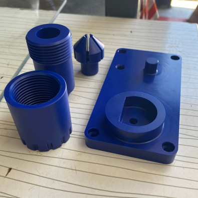 Blue plastic electrical conduit fittings and a junction box on a wooden surface.