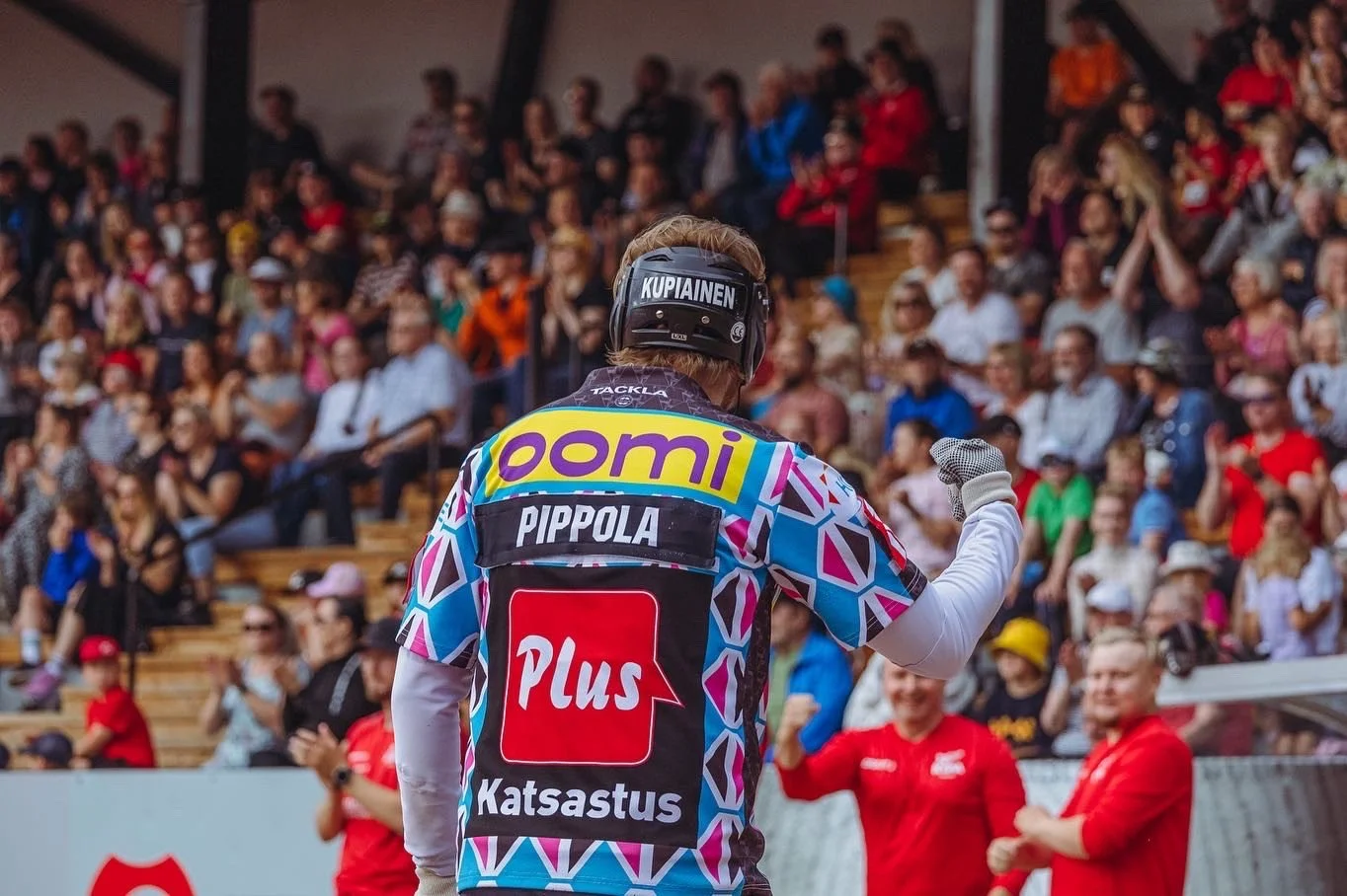 Urheilija tuulettaa niin, että hänen nyrkkinsä on pystyssä, katsomossa väkijoukko ihailee.