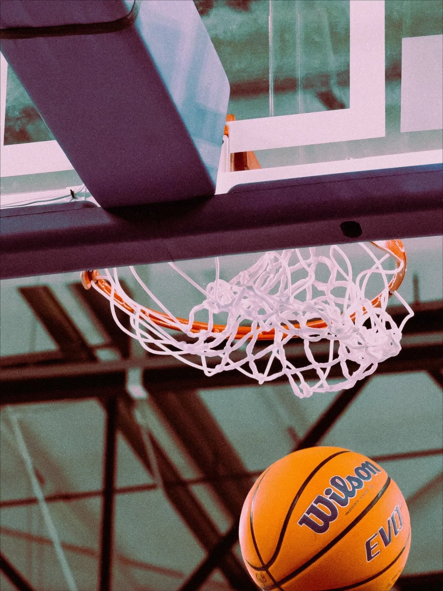 Koripallopallolla ja kori. Kuvassa on myös osia koripallokentän rakenteista ja katosta.