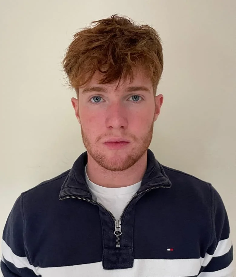 Illustration of a faceless person with short brown hair, wearing a dark blue shirt, against a circular blue background.