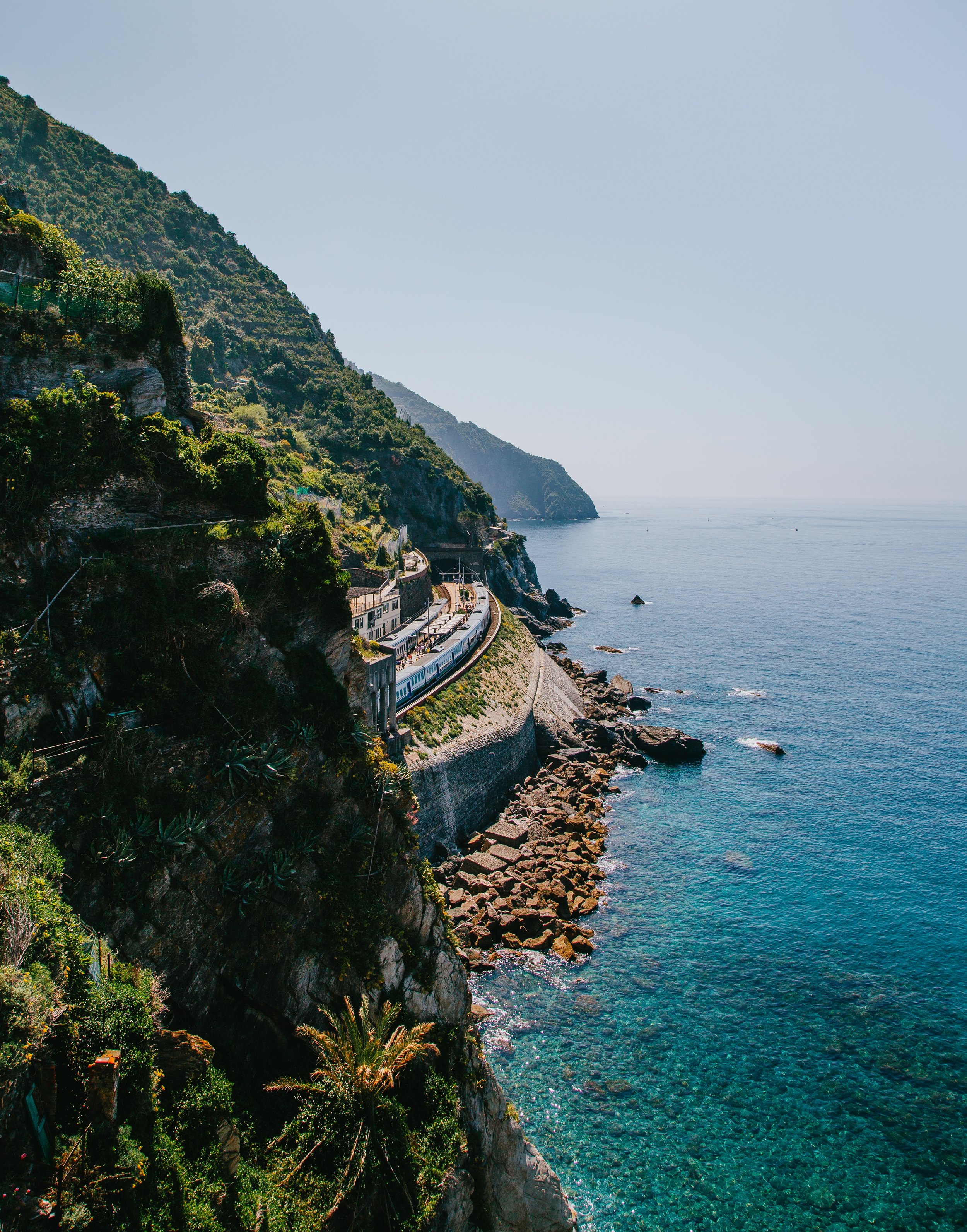 vertical-shot-green-mountains-by-body-ocean.jpg