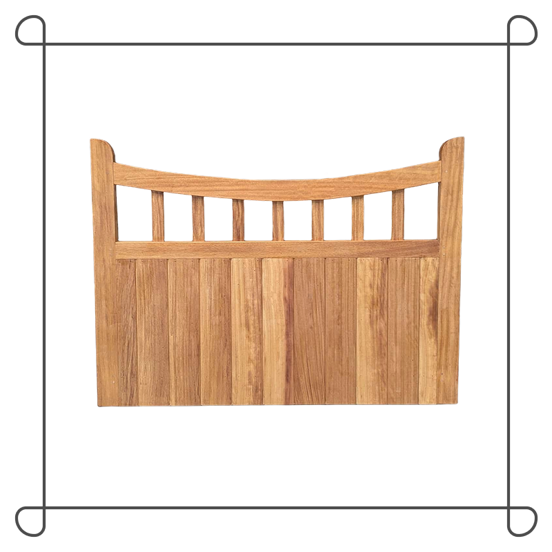 A backyard with a wooden gate, a gravel pathway, a garden bed, a lush green lawn, and a house with many windows and a brick chimney, surrounded by trees and bushes.