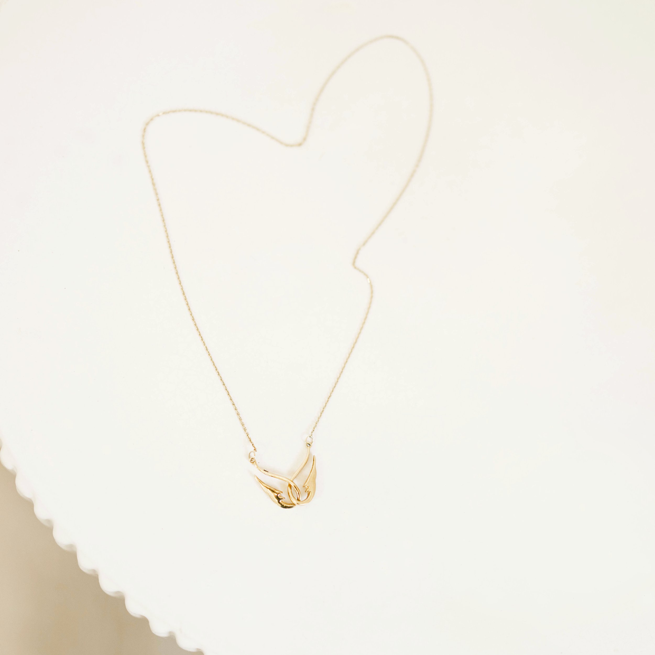 Hope 14K gold intelocked wing necklace front view on table.jpg