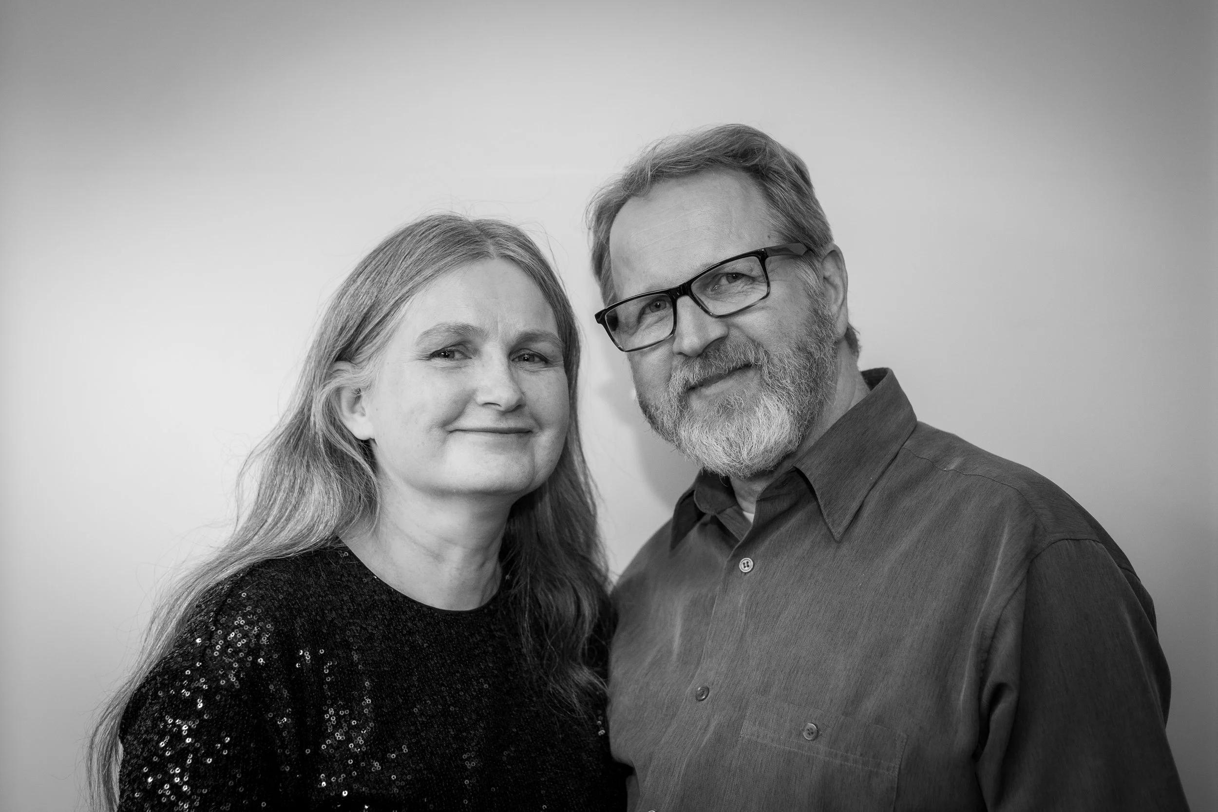 Kuva kahdesta ihmisestä, nainen ja mies, nauravina ja katselevina kameraan, mustavalkoinen kuva.