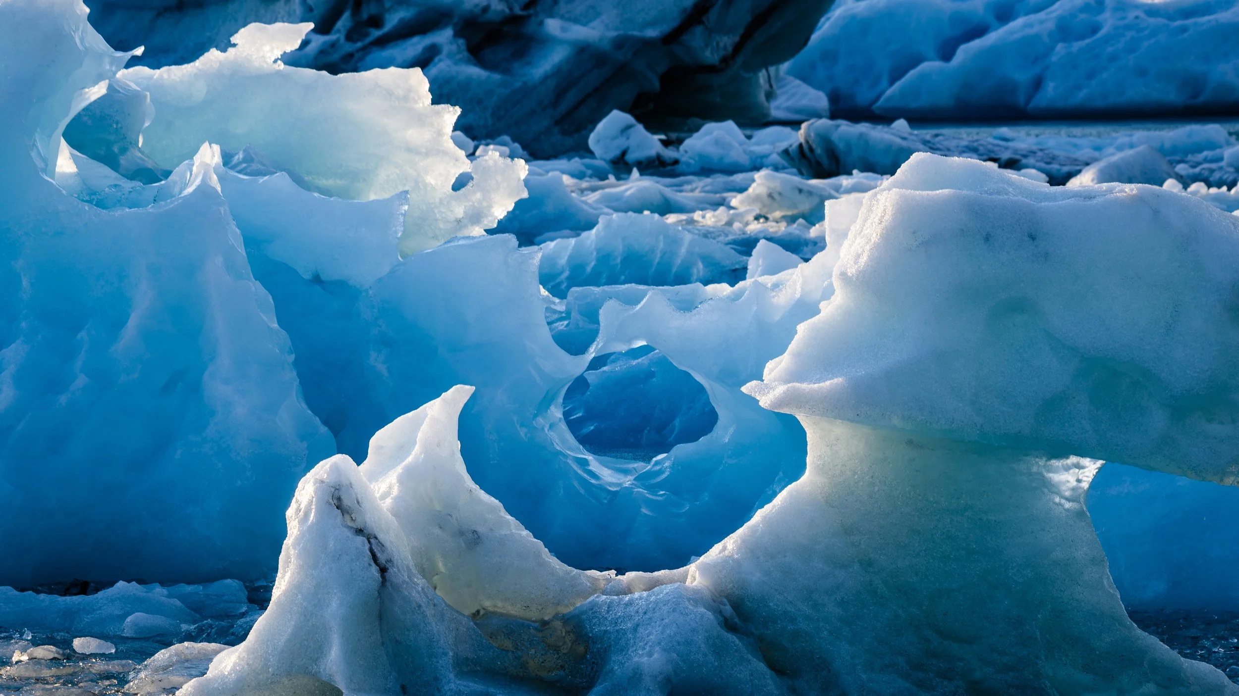Close-up of melting blue and white icebergs in the ocean.