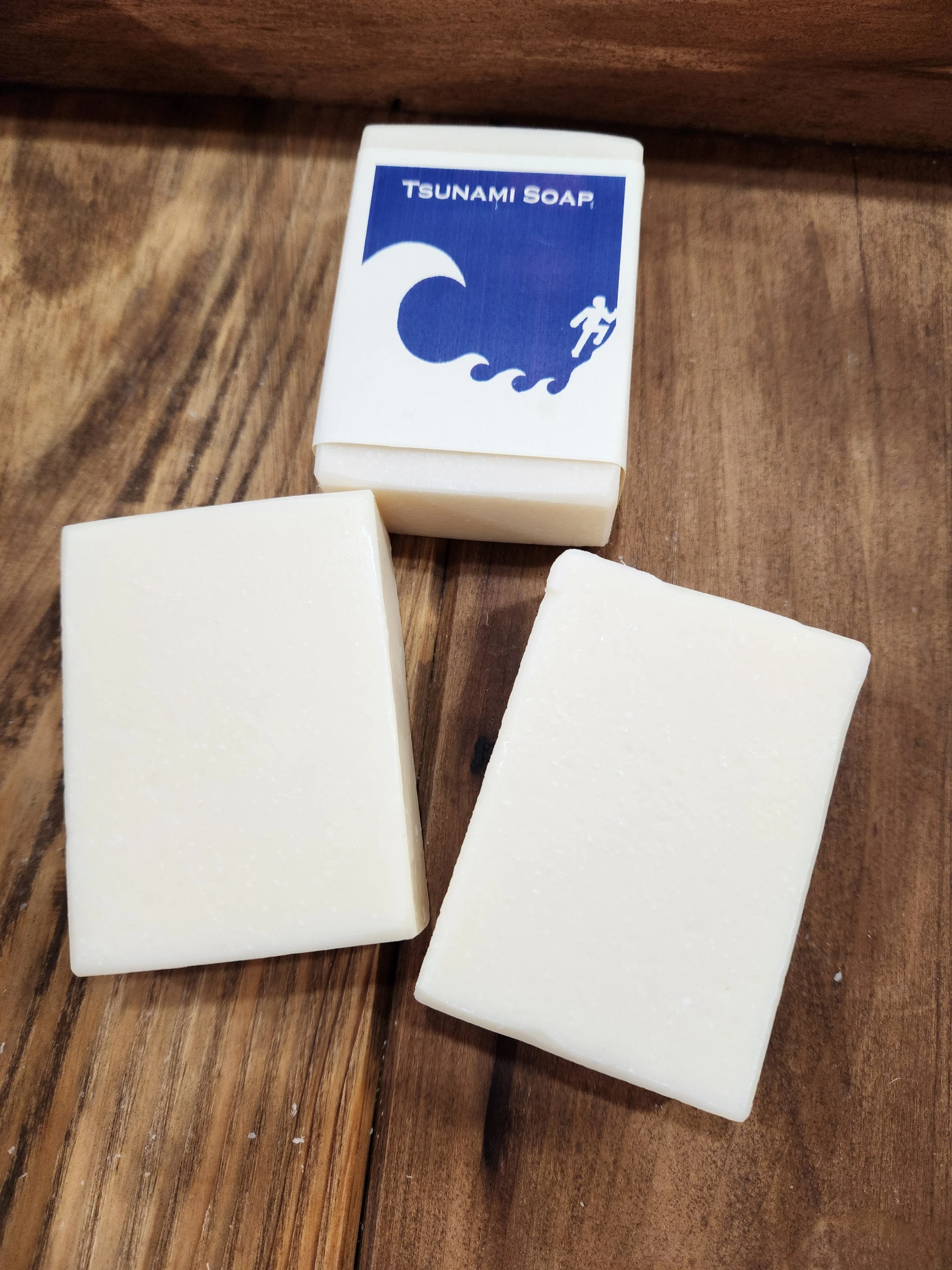 3 bars of white soap on a wooden base, the Tsunami pictogram is noted on the front label.