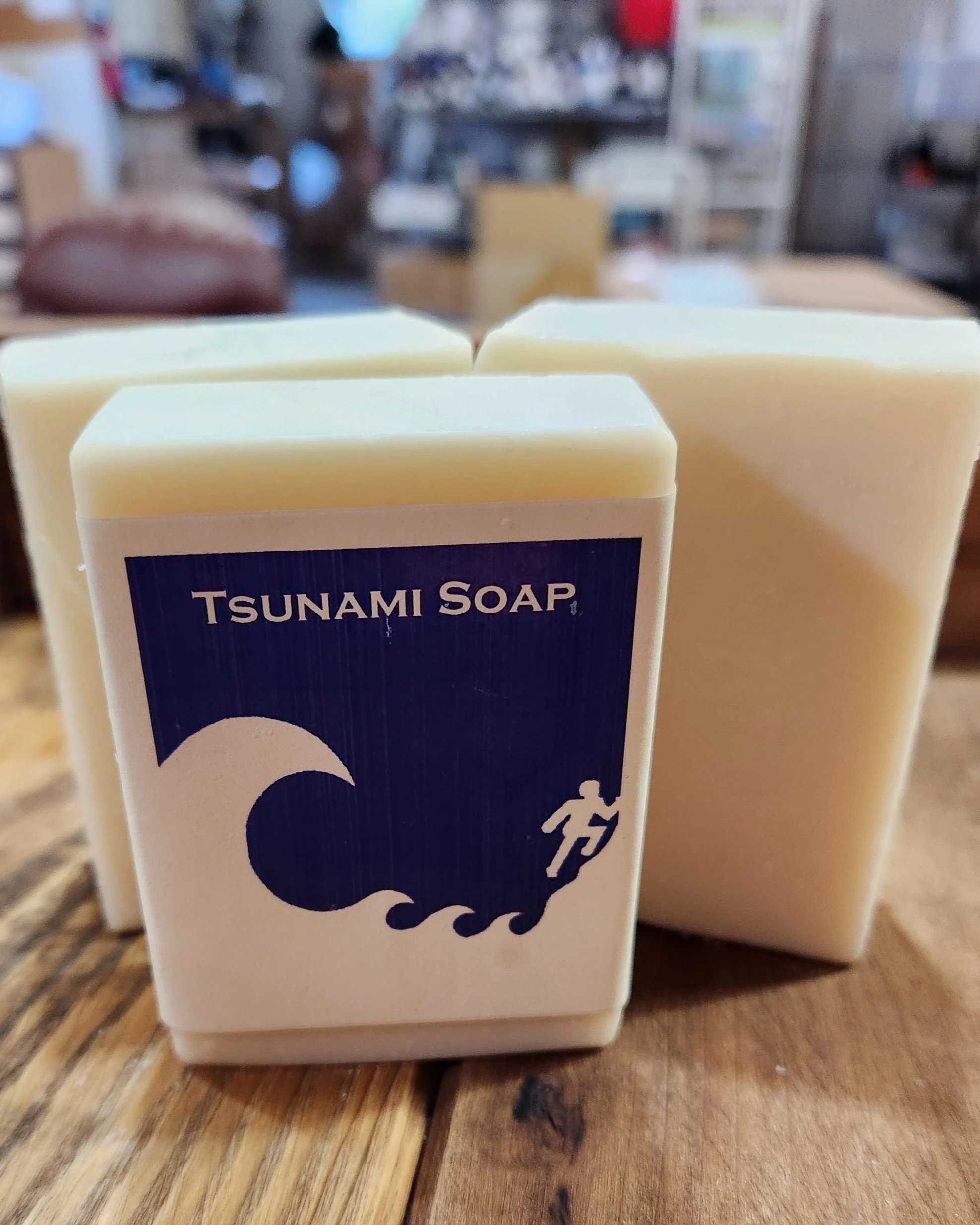 3 bars of white soap on a wooden base, the Tsunami pictogram is noted on the front label.