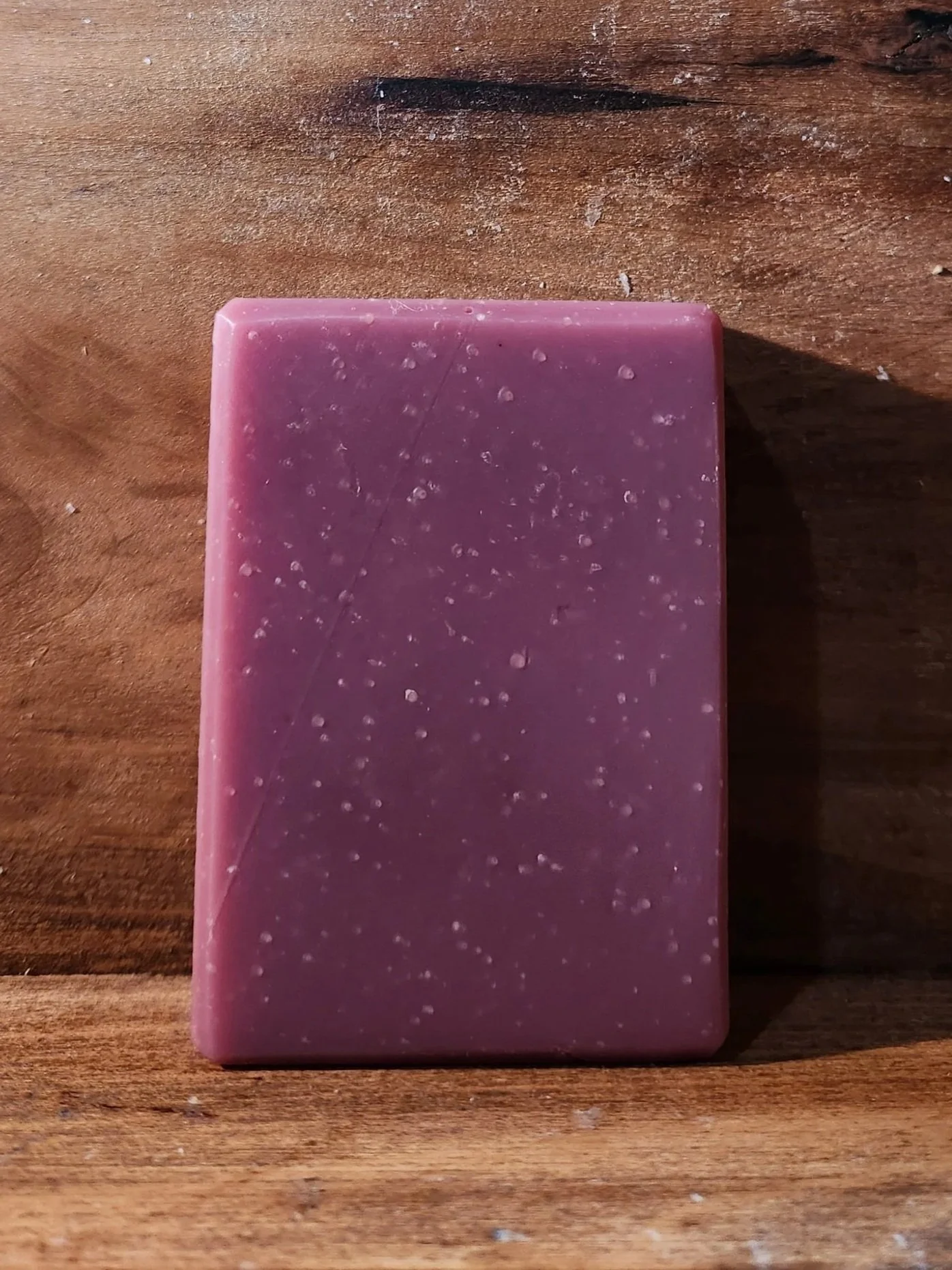 1 bar of purple soap with a wood grain background.