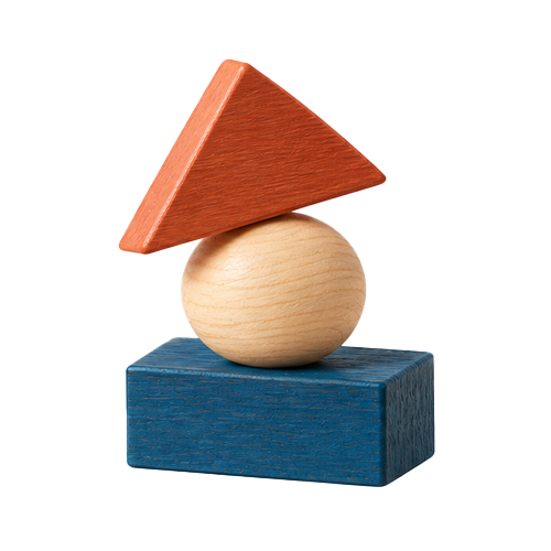 Wooden geometric blocks stacked in an abstract sculpture, including a blue rectangular block at the bottom, a round beige ball in the middle, an orange triangular prism on top of the ball, and a red triangular prism resting on the orange one.
